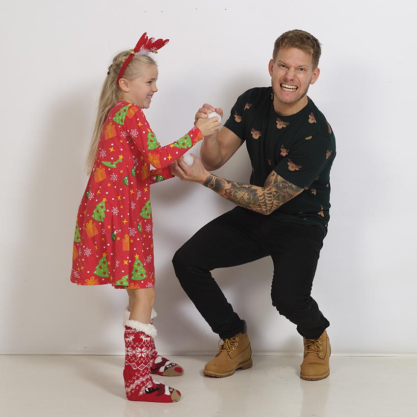 Un enfant portant une robe de Noël rouge et un homme.