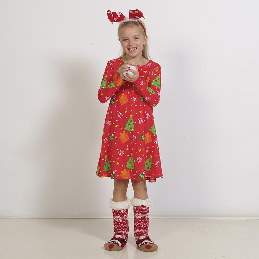 Un enfant portant une robe de Noël rouge.