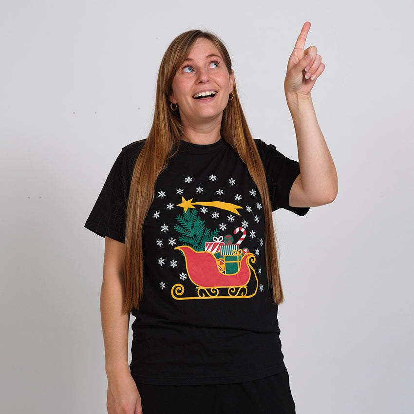 En kvinde iført en sort jule T-shirt med en slæde på.