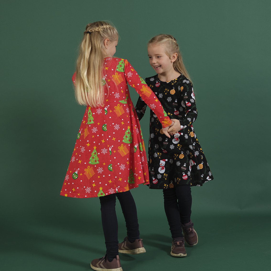 Deux enfants portant chacun leur propre robe de Noël.
