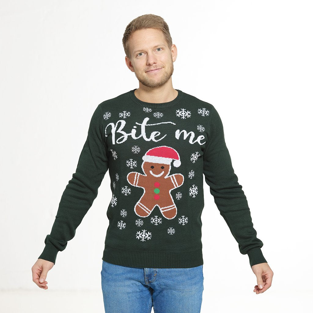 Un homme portant un pull de Noël vert avec un gâteau et la citation 
