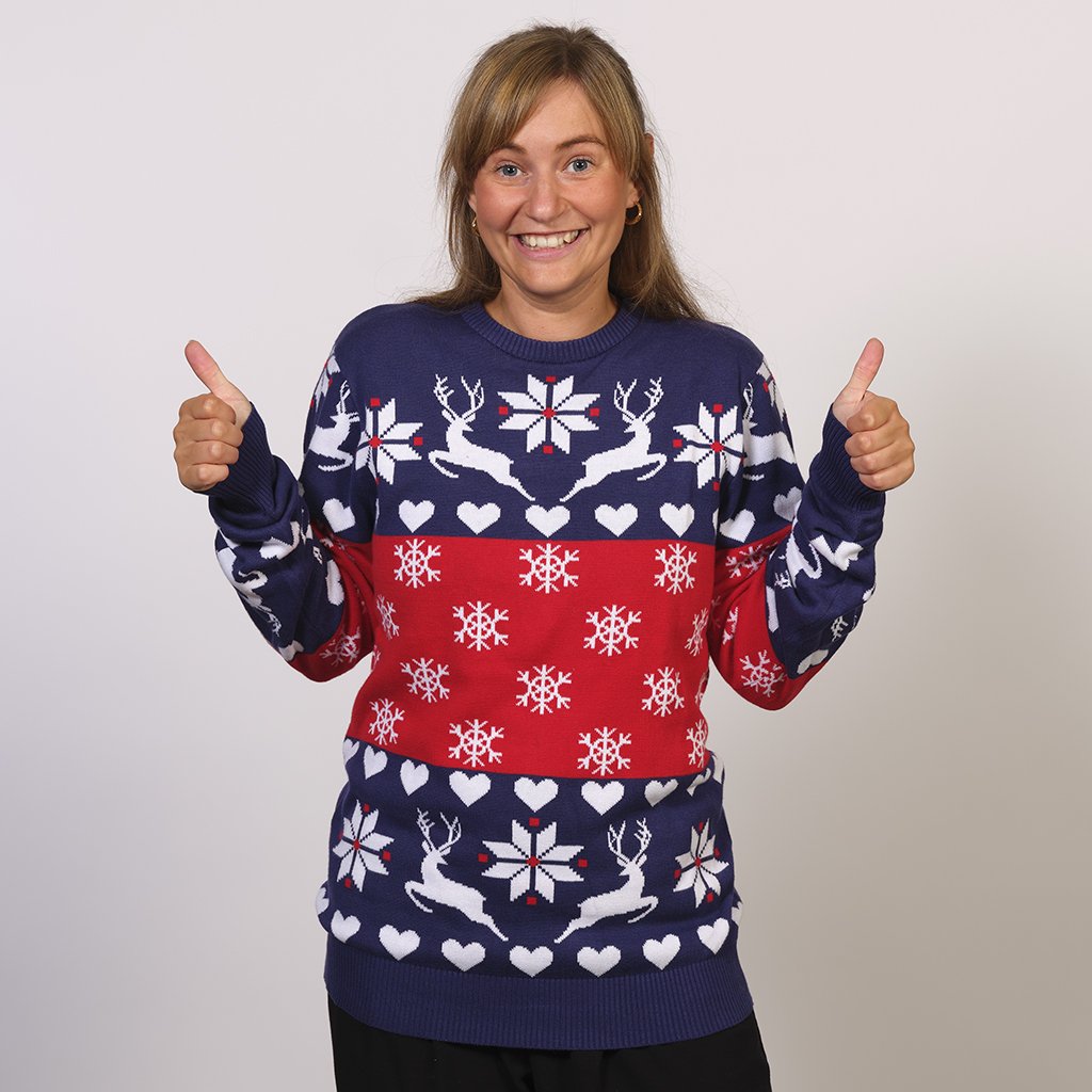 Une femme portant un pull de Noël bleu et rouge avec des rennes et un motif de Noël.