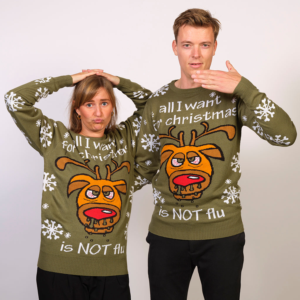 Un couple portant un pull de Noël vert avec la citation 