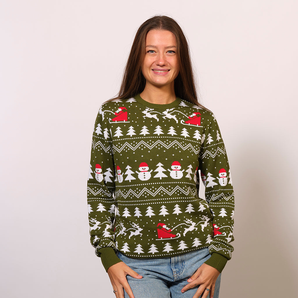 Une femme portant un pull de Noël vert avec des arbres de Noël, des pères Noël et un motif de Noël.
