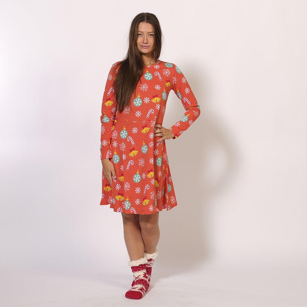 Une femme souriante portant une robe de Noël rouge.