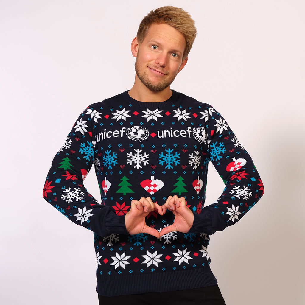 En mand iført en julesweater med Unicefs logo på.