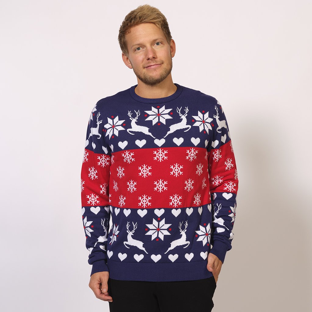 Un homme portant un pull de Noël bleu et rouge avec des rennes et un motif de Noël.