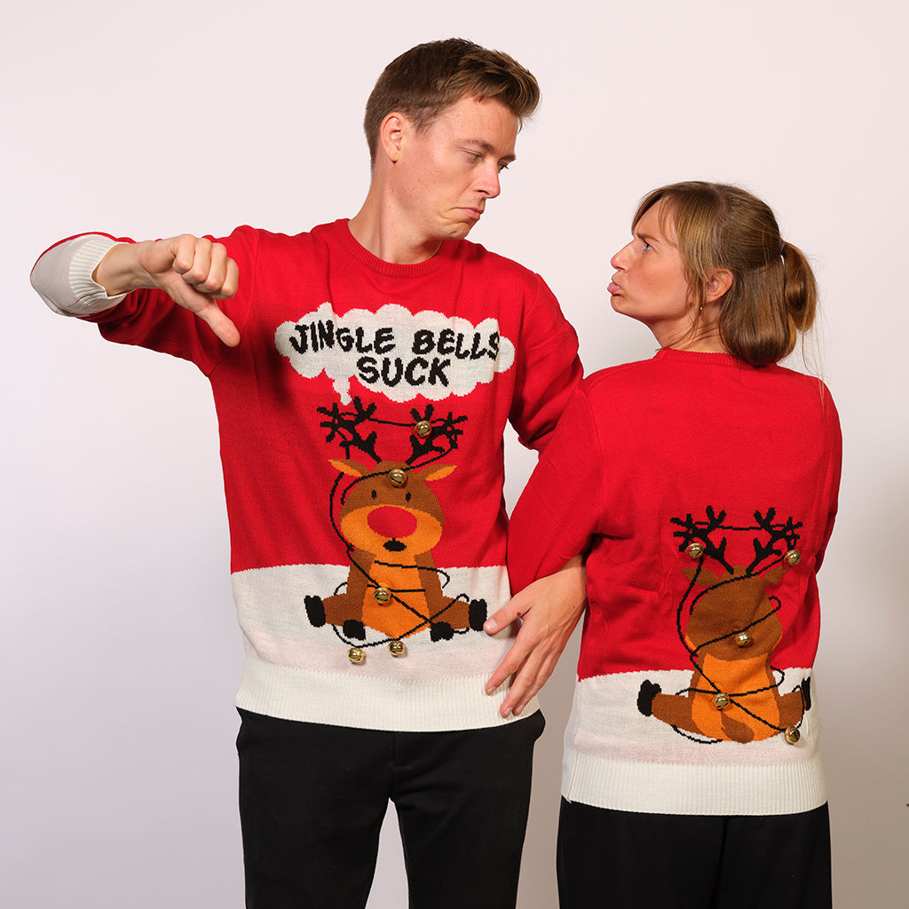 Un couple portant un pull de Noël rouge avec la citation 