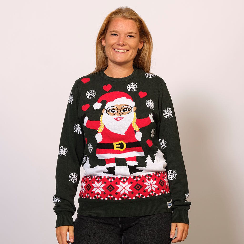 En smilende kvinde iført en julesweater med en nisse og snefnug.
