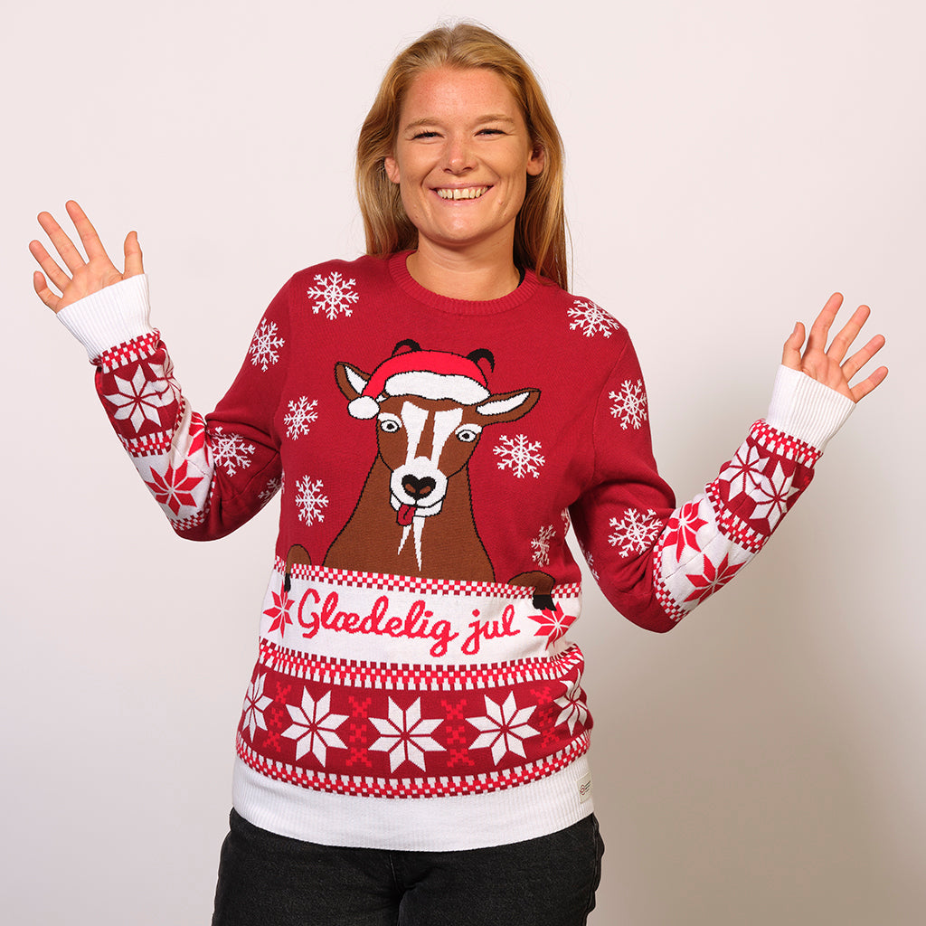En glad kvinde iført en julesweater med citatet 