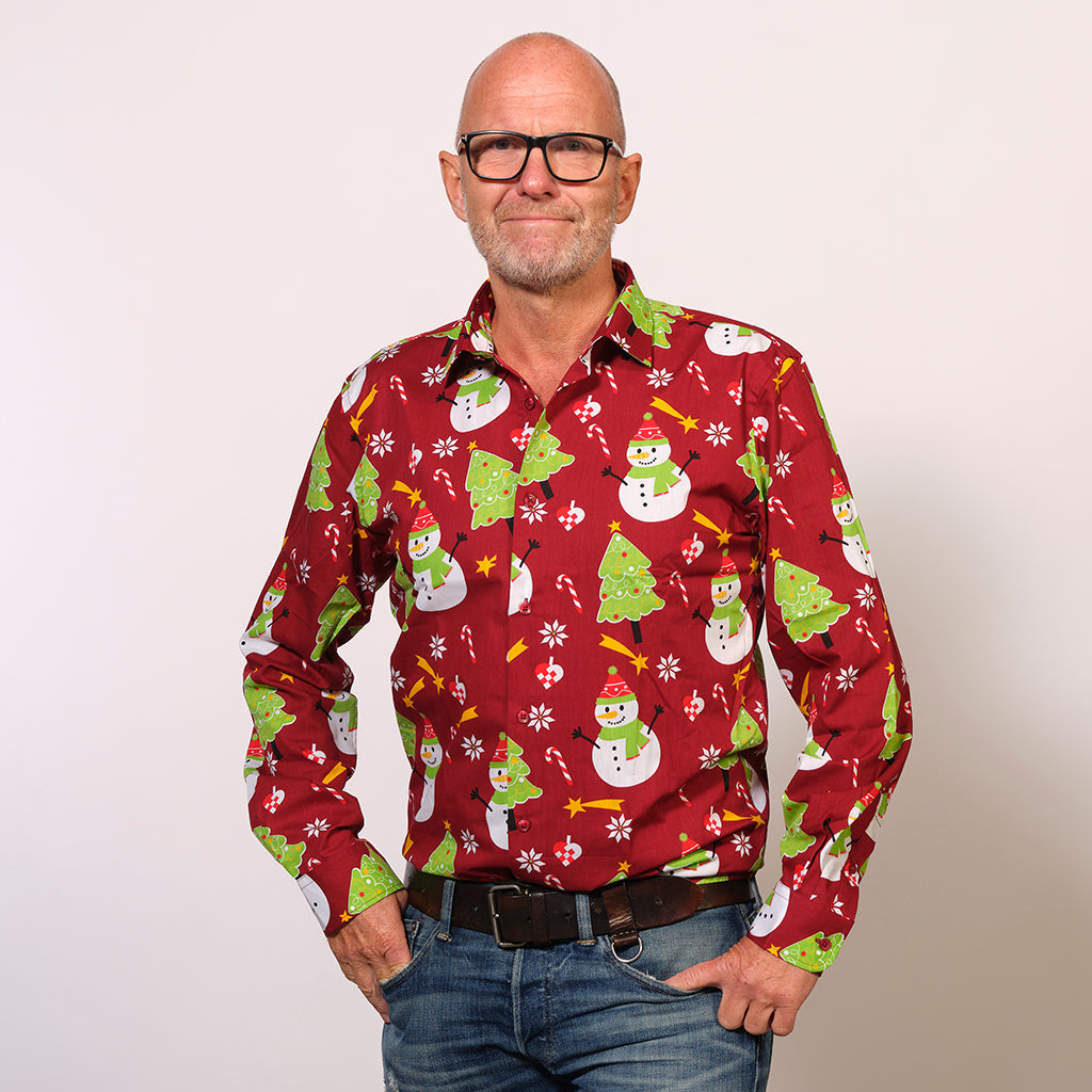 En mand med briller iført en rød juleskjorte.