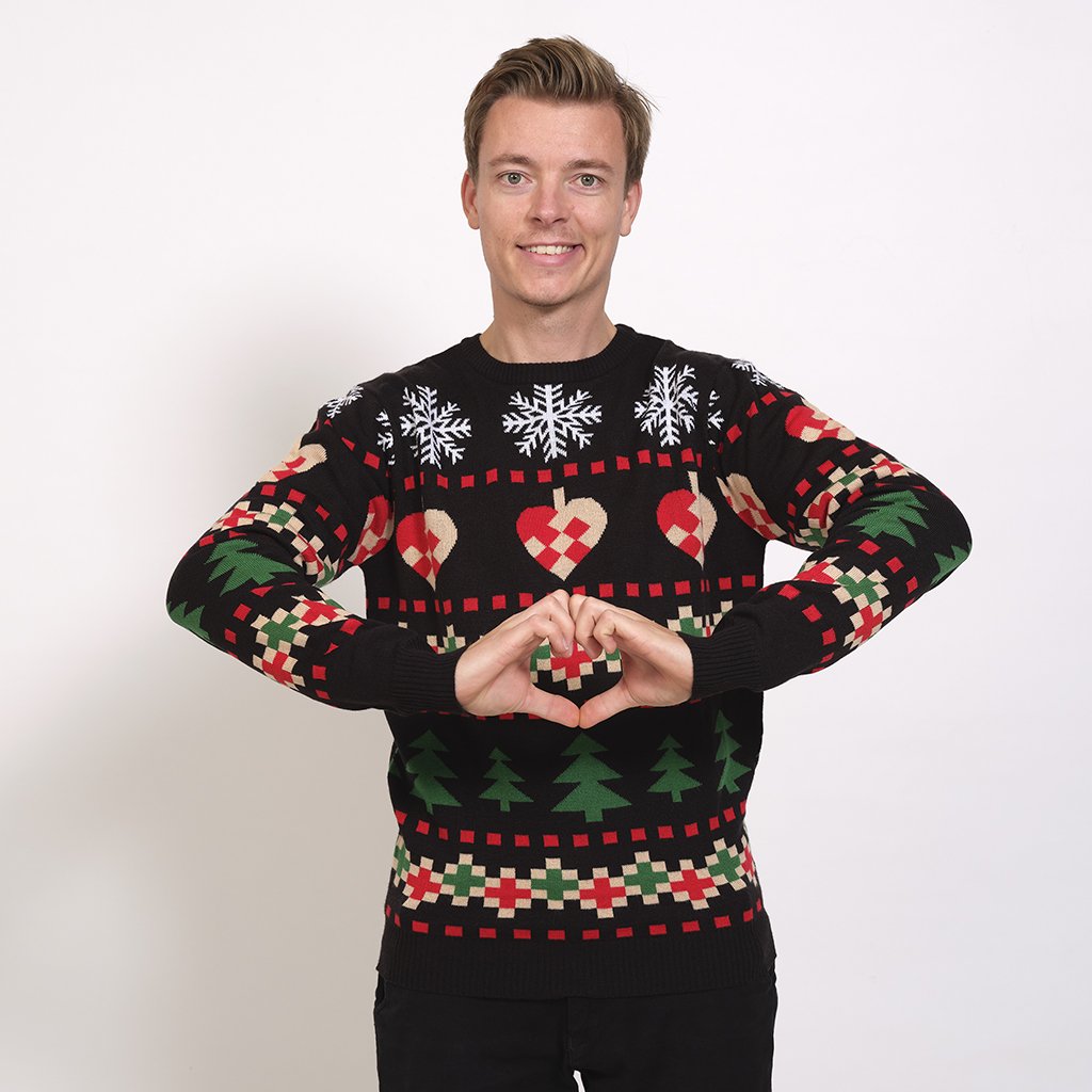 Un homme portant un pull de Noël noir avec un imprimé de Noël.