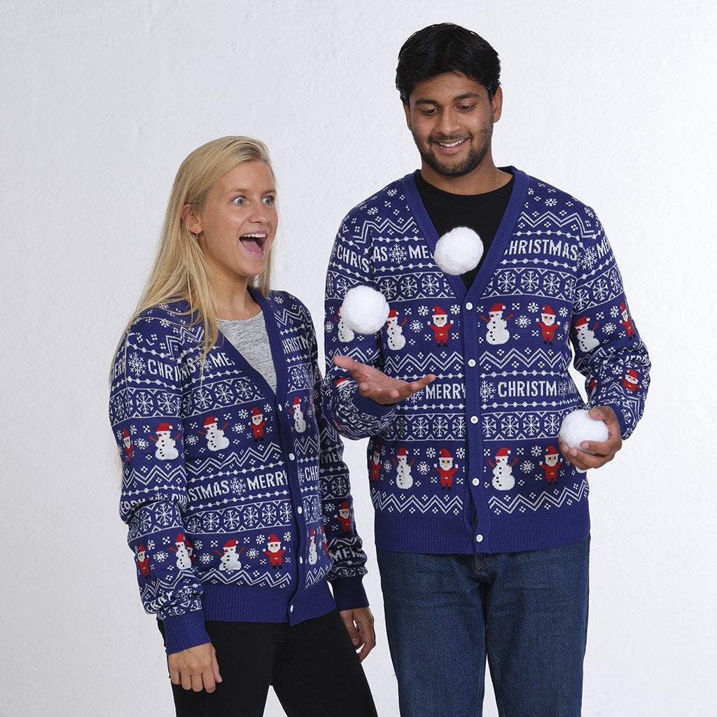 Un couple portant un gilet de Noël bleu avec des lutins et des bonshommes de neige.