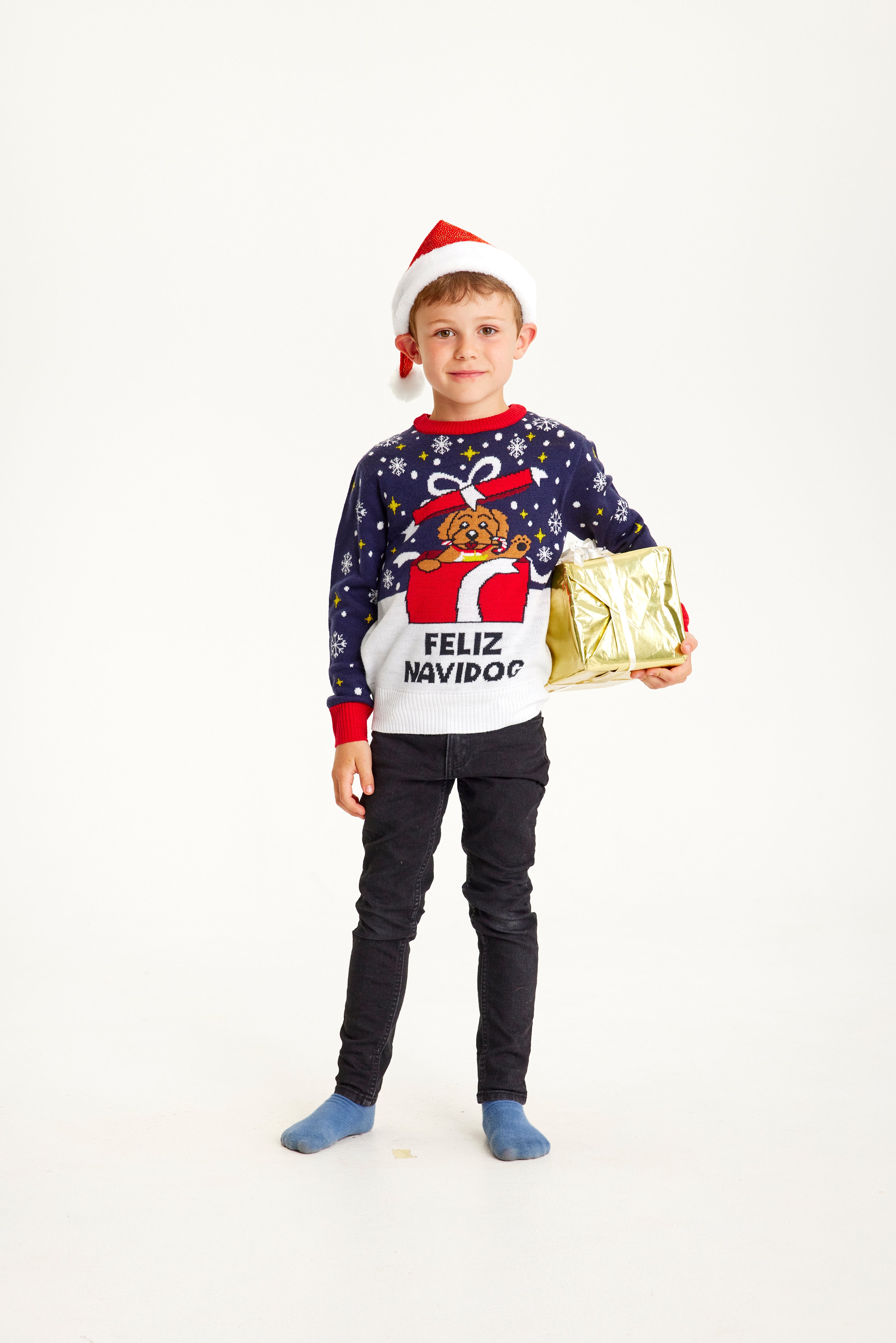 Un enfant porte un pull de Noël avec un chien dessus.