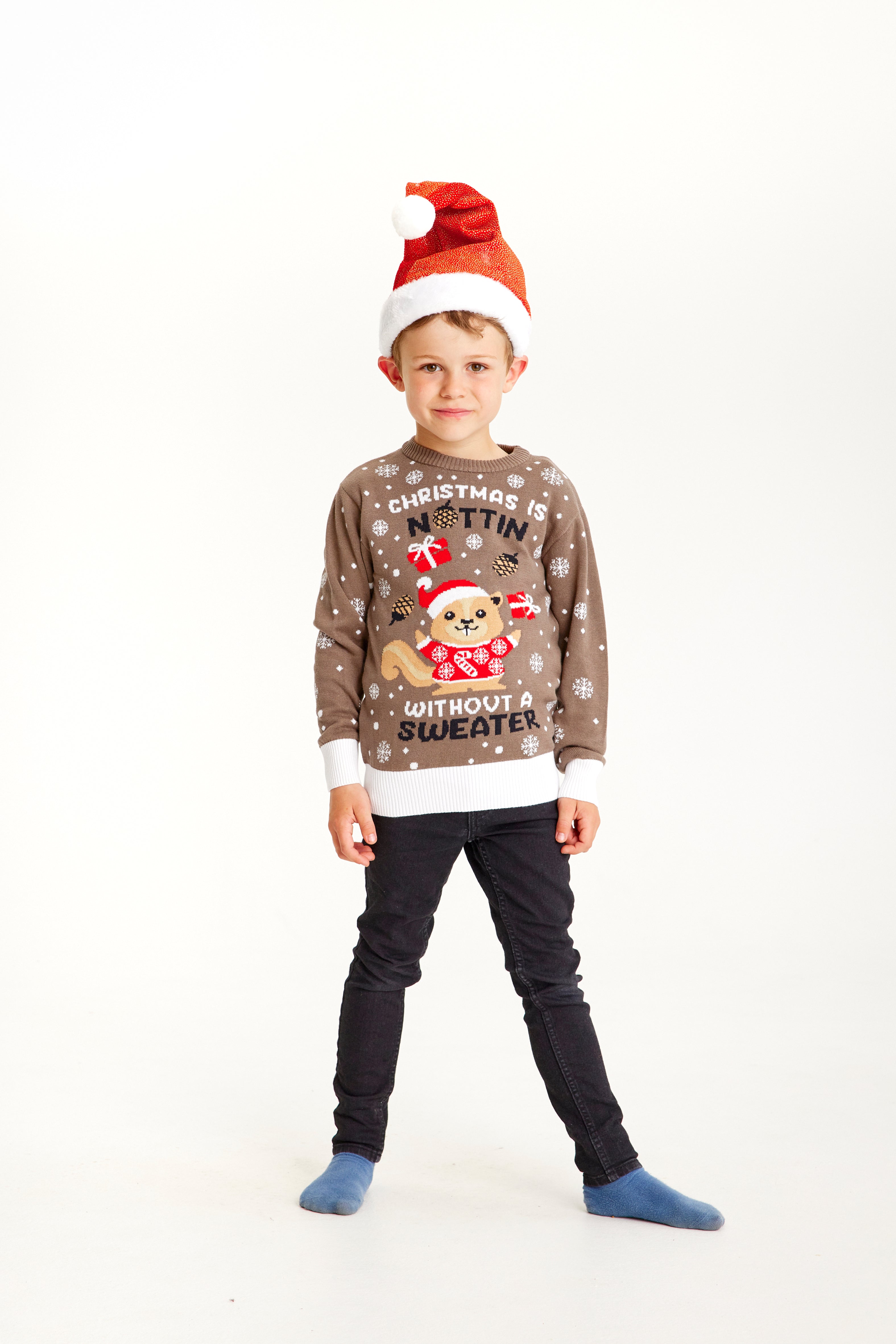 Un enfant portant un pull de Noël marron avec la citation 