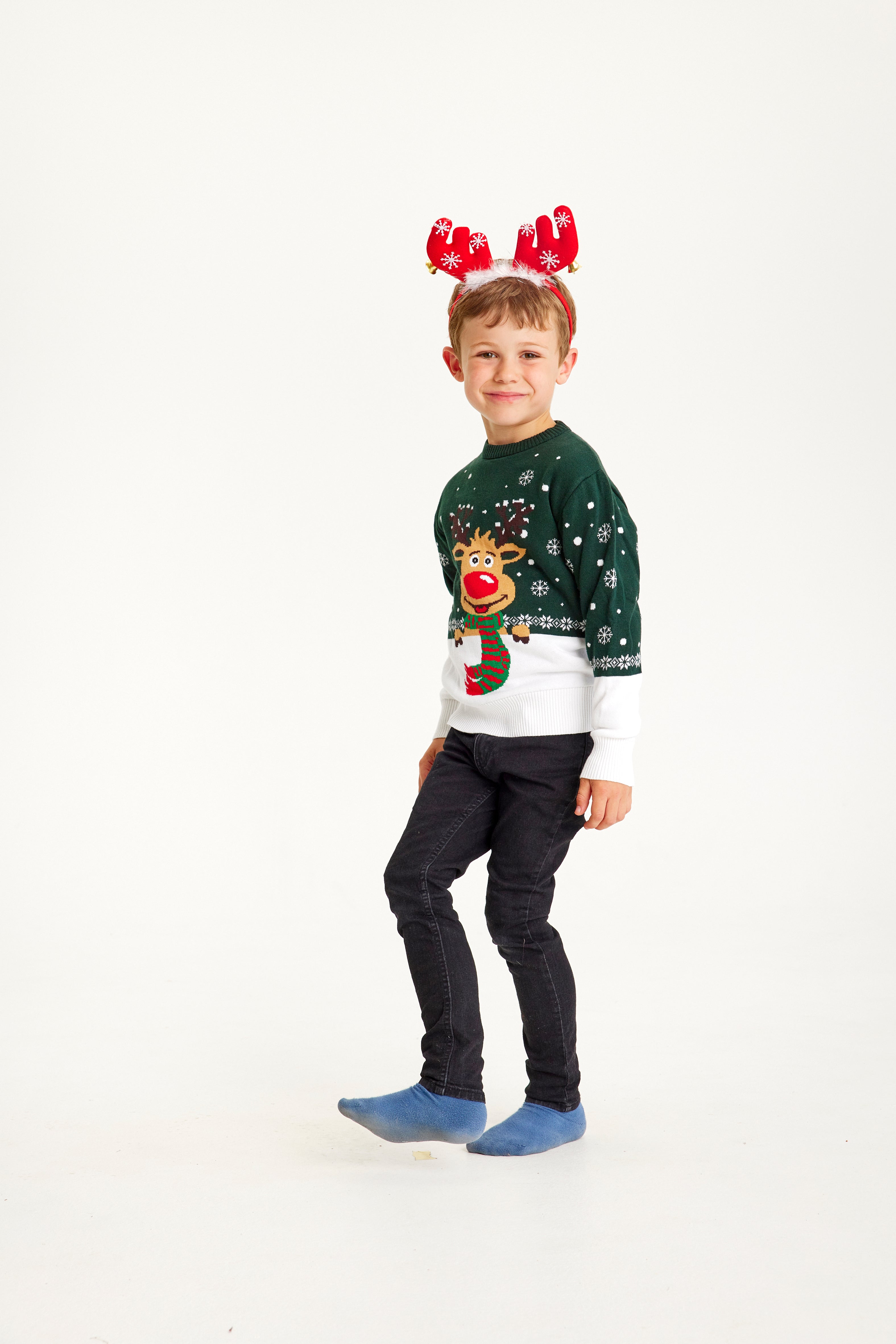 Un enfant portant un pull de Noël vert et blanc avec Rudolph.