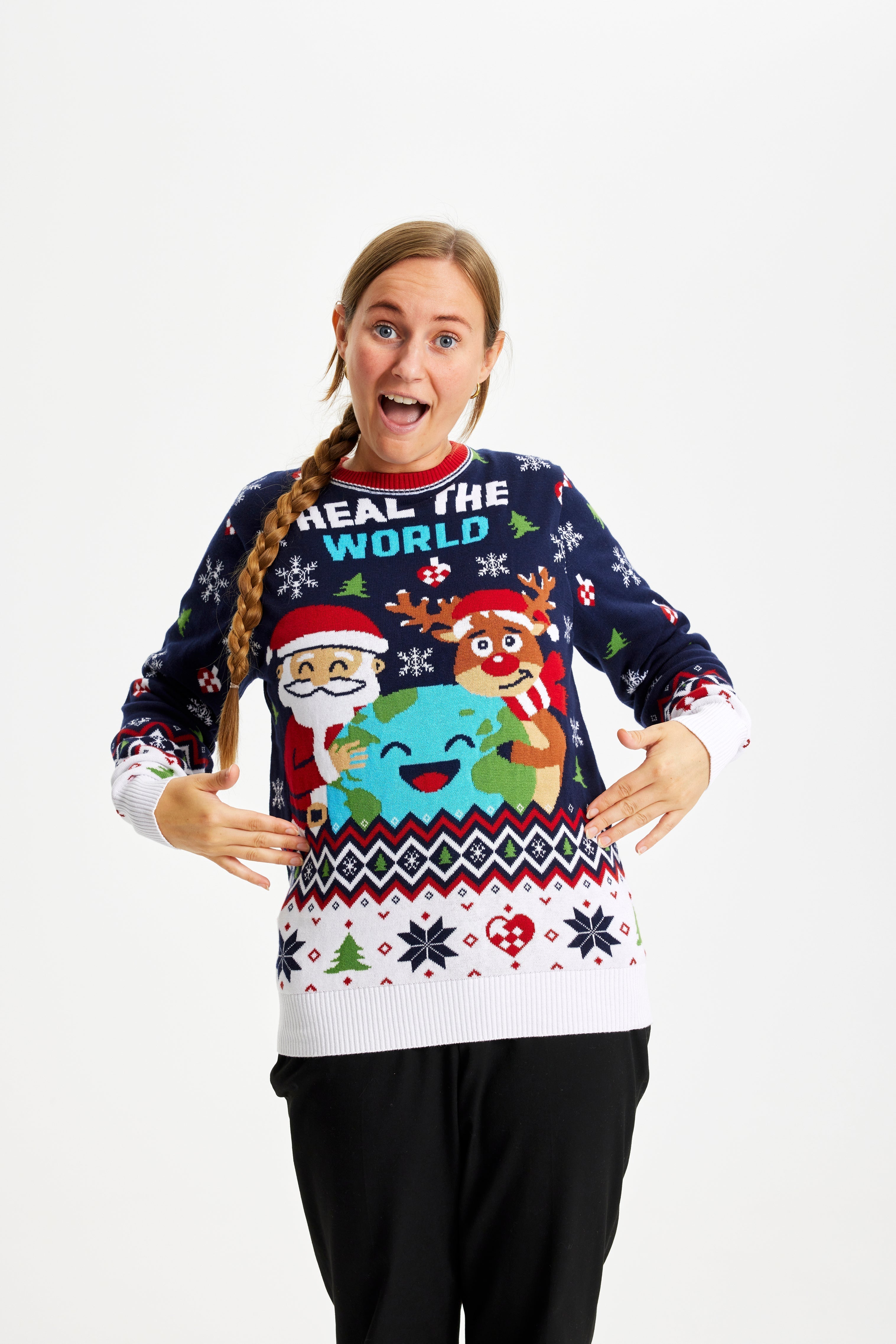 Une femme pose vêtue d'un pull de Noël bleu et blanc portant la citation 