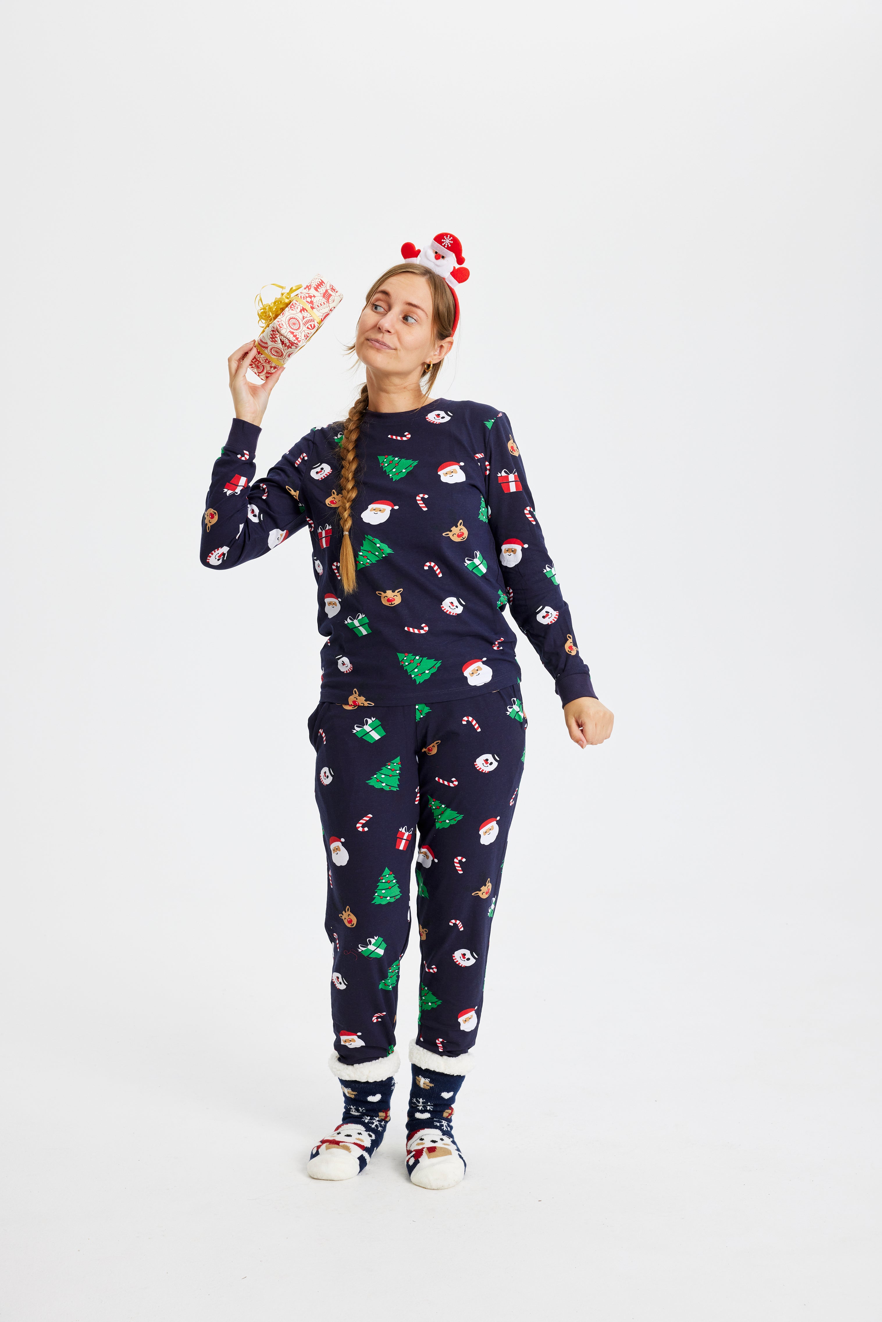 Une femme enthousiaste portant un pyjama de Noël avec des arbres de Noël.