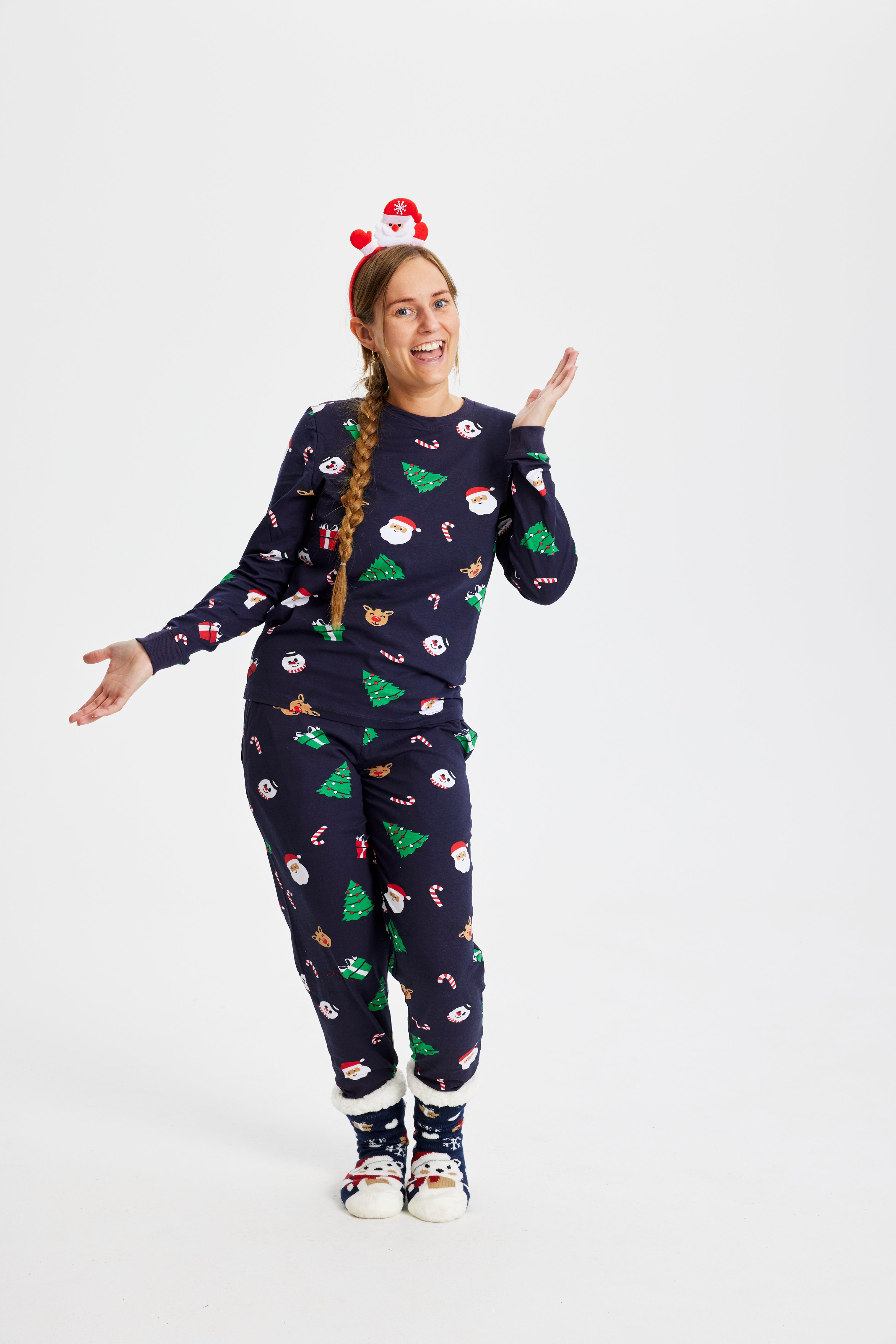 Une femme souriante portant un pyjama de Noël avec des arbres de Noël.