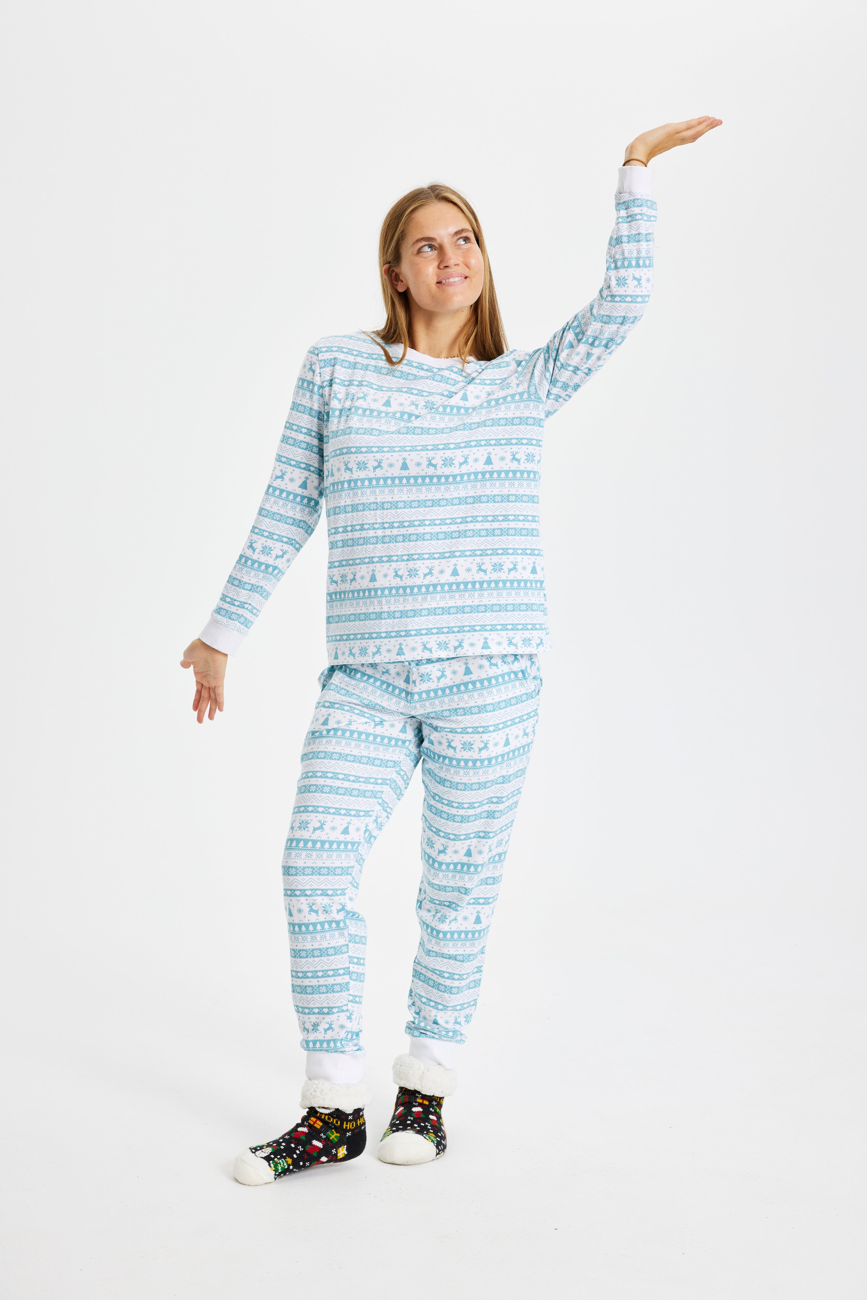 Une femme posant avec un pyjama de Noël bleu clair.
