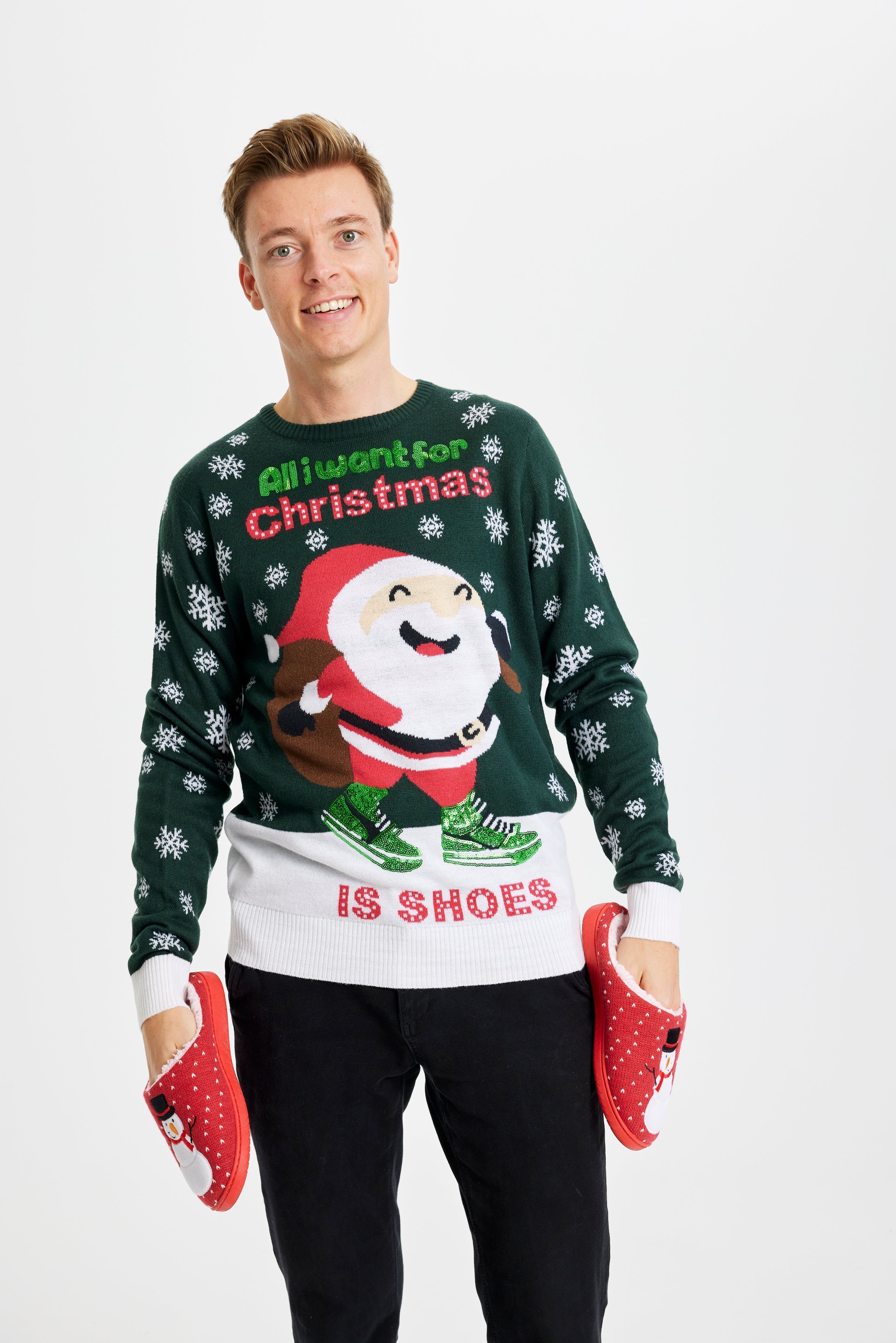 Un homme portant un pull de Noël vert et blanc avec la citation 