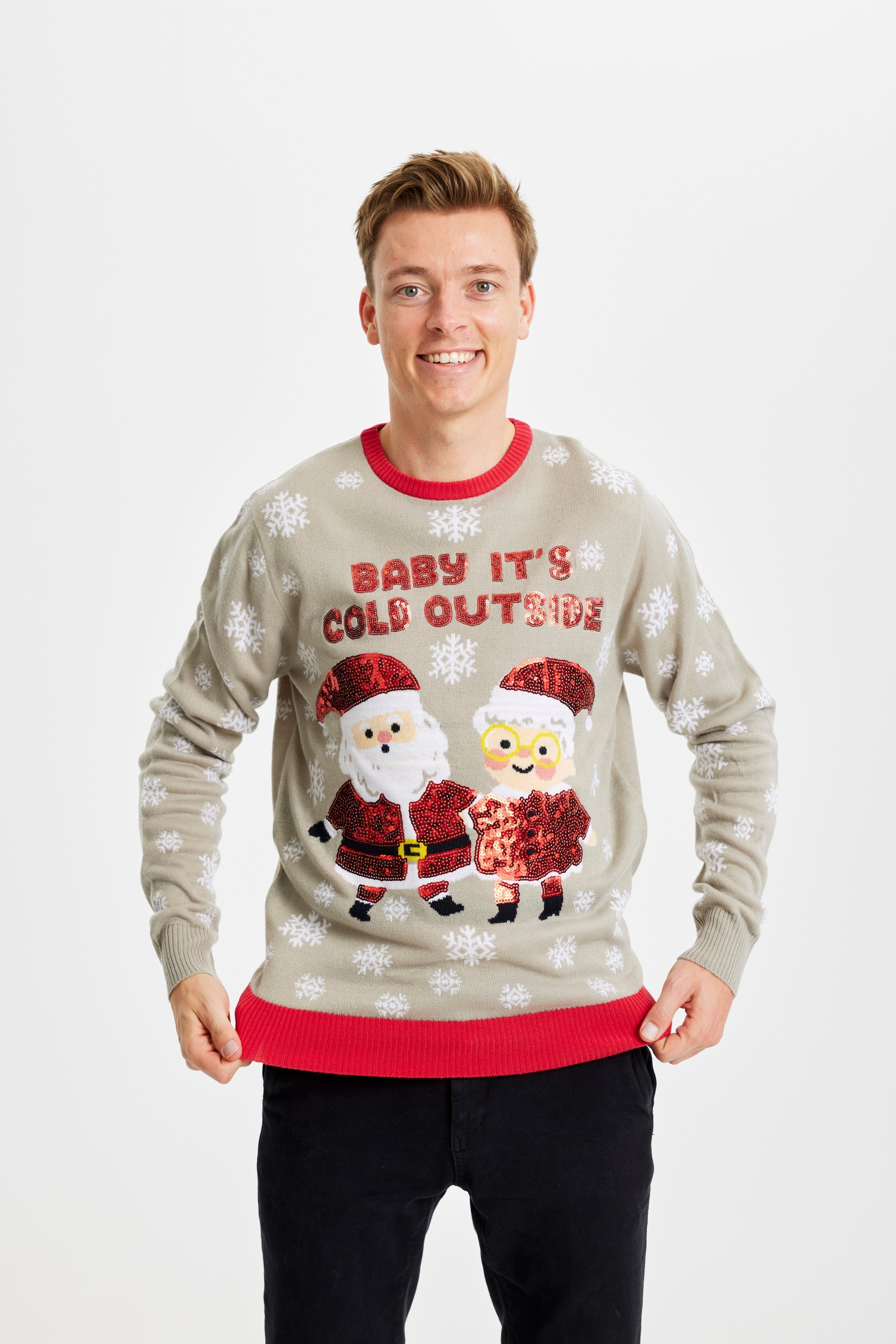 Un homme souriant portant un pull de Noël gris avec la citation 