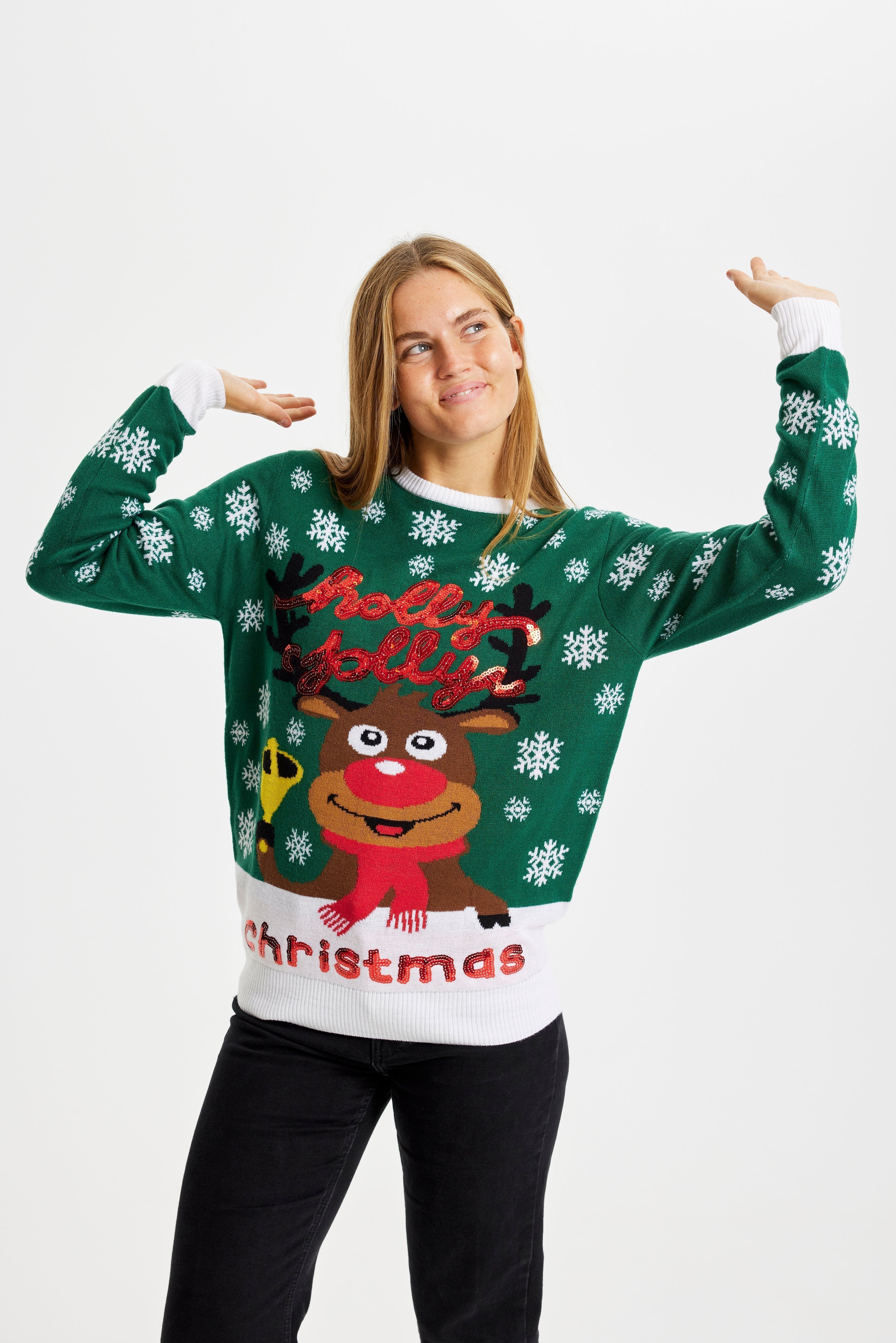 Une femme qui pose, portant un pull vert de Noël avec Rudolph.