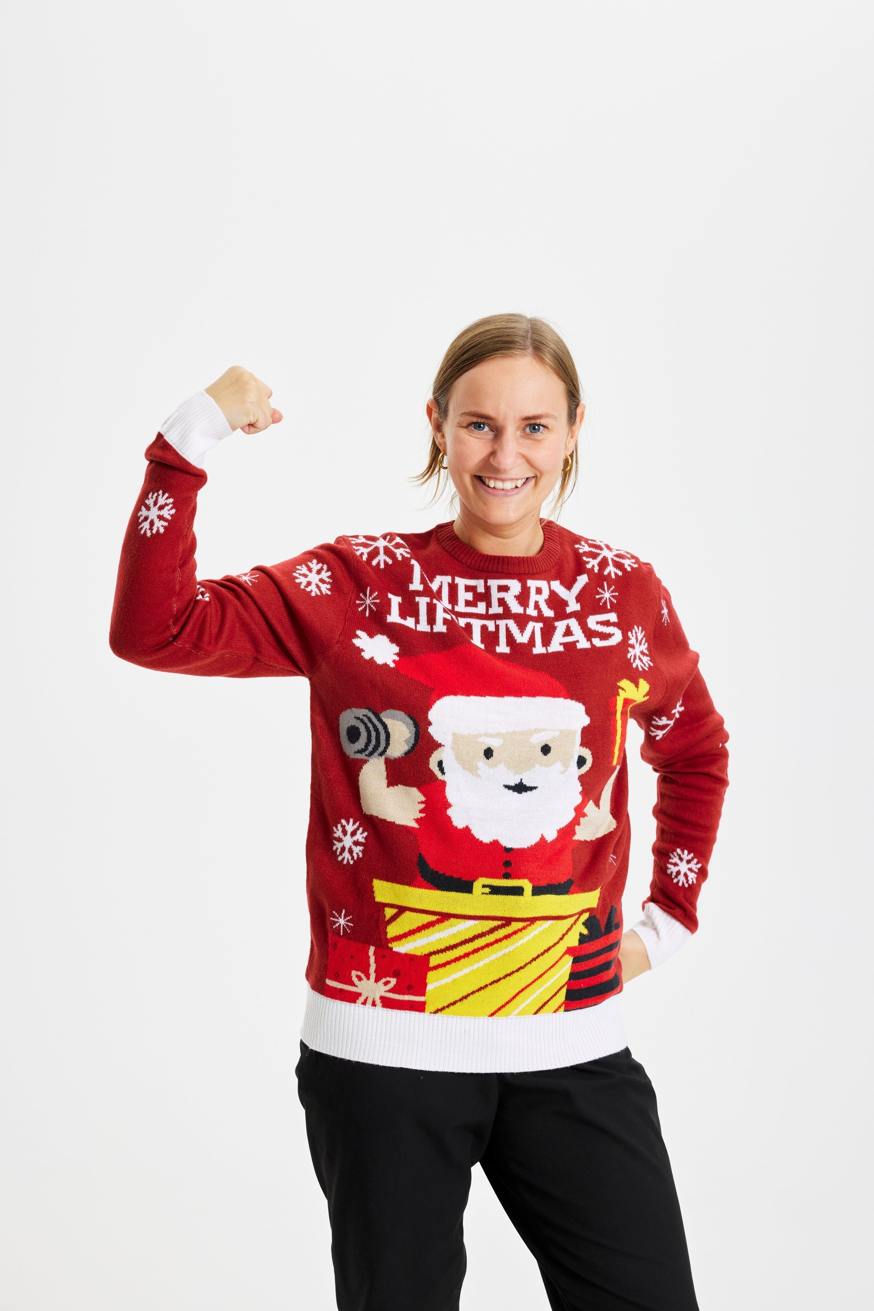 Une femme posant avec un pull rouge de Noël avec la citation 