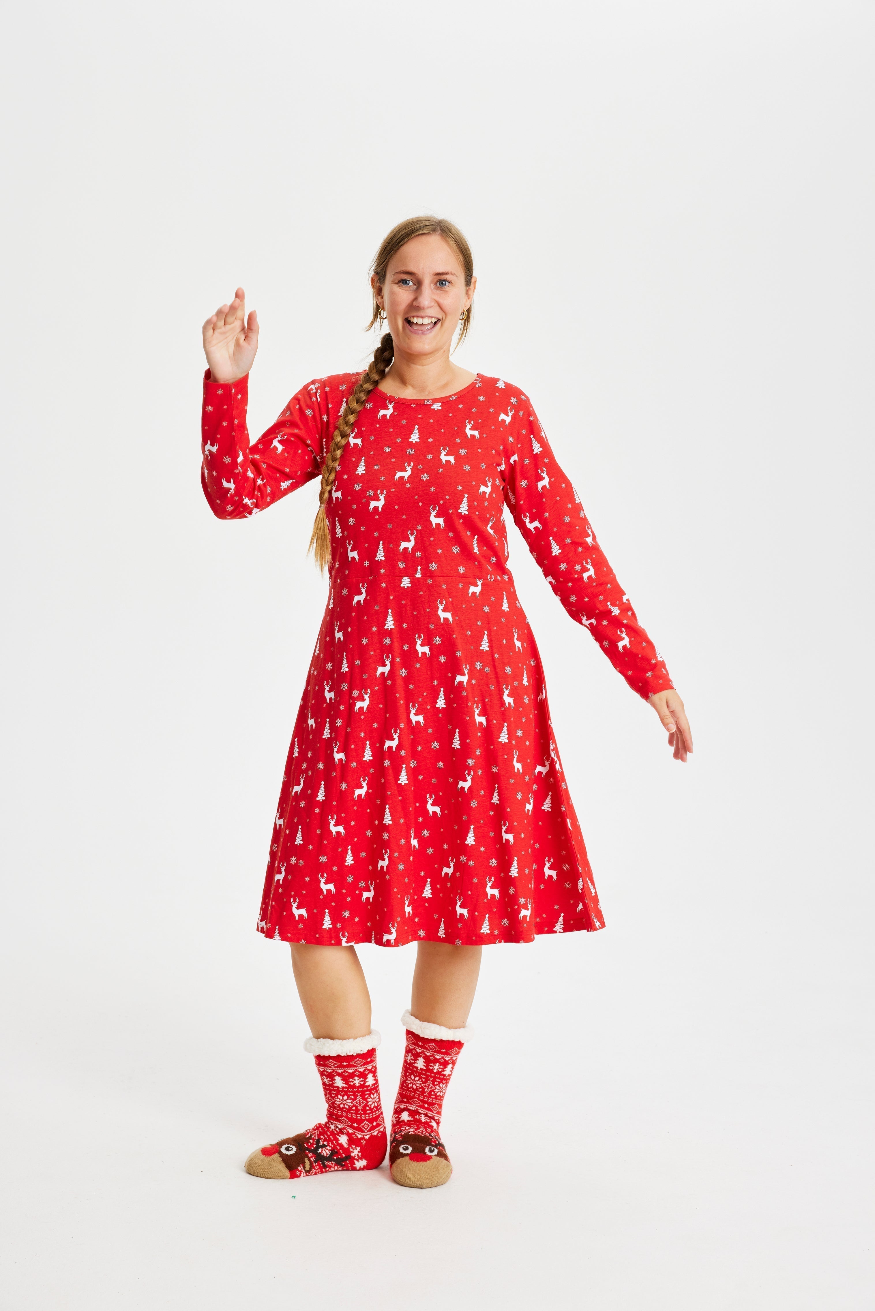 Une femme posant avec une robe de Noël rouge.