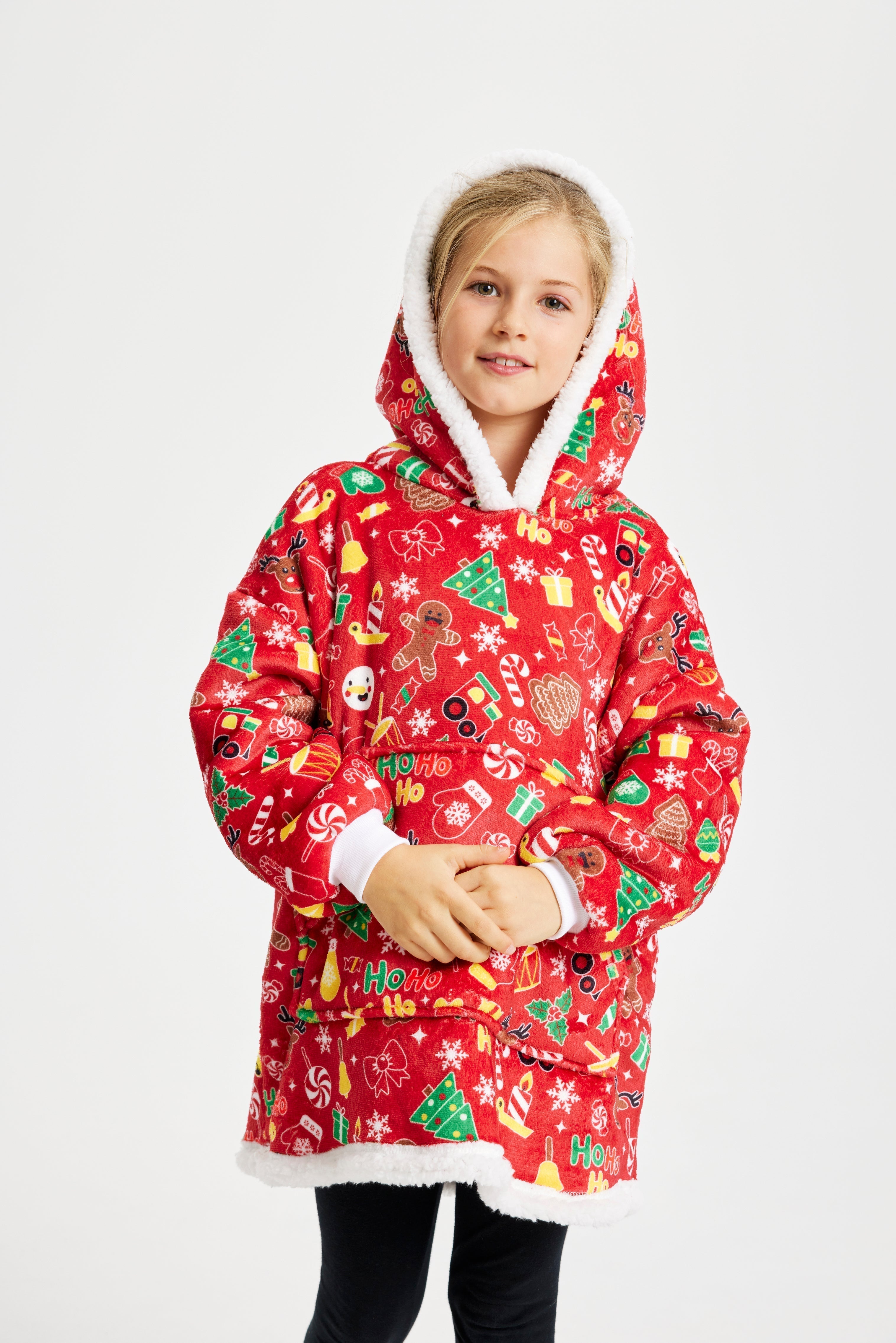 Un enfant souriant porte des sweats à capuche à motifs de Noël.