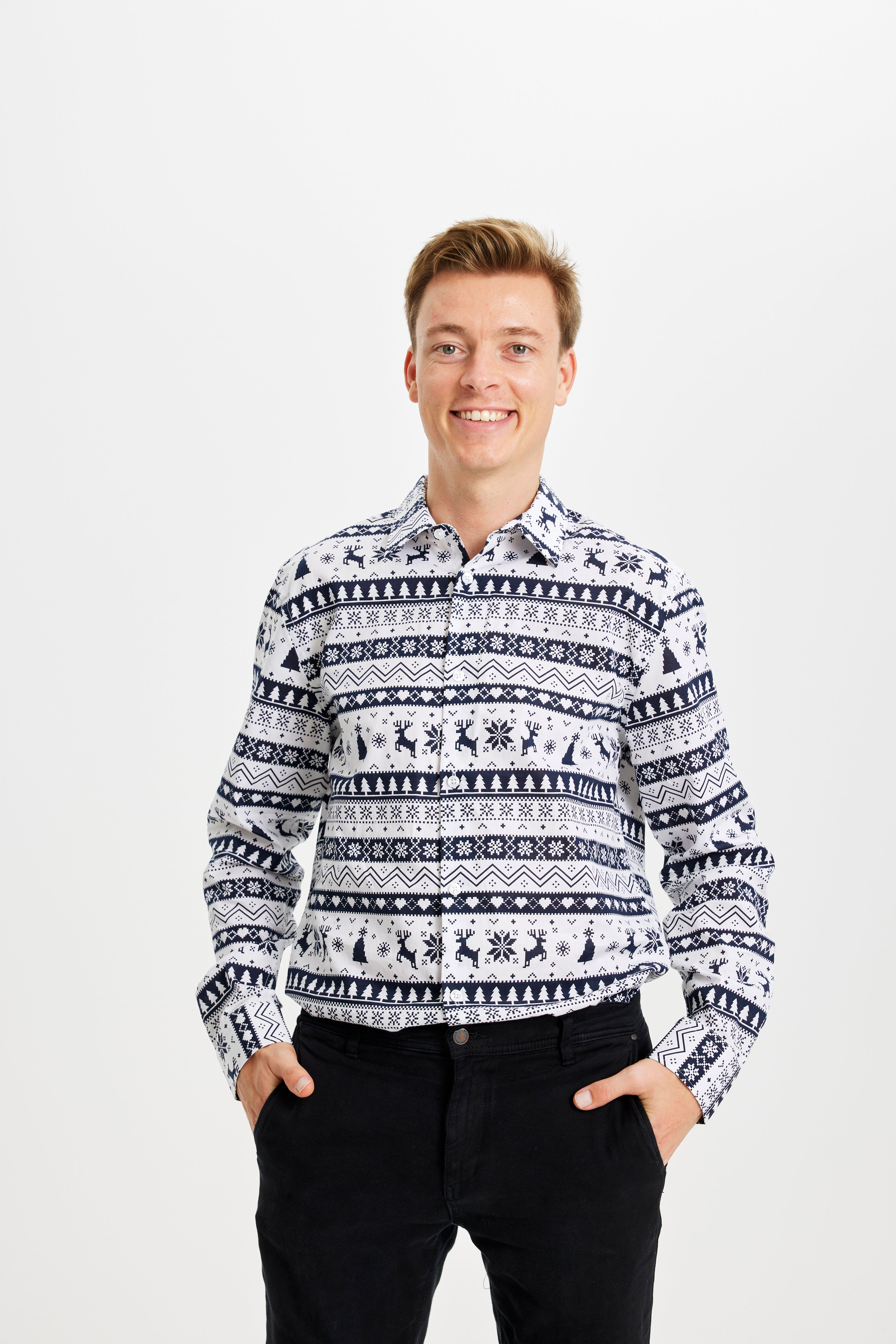 Un homme souriant portant une chemise de Noël rayée blanc et bleu.