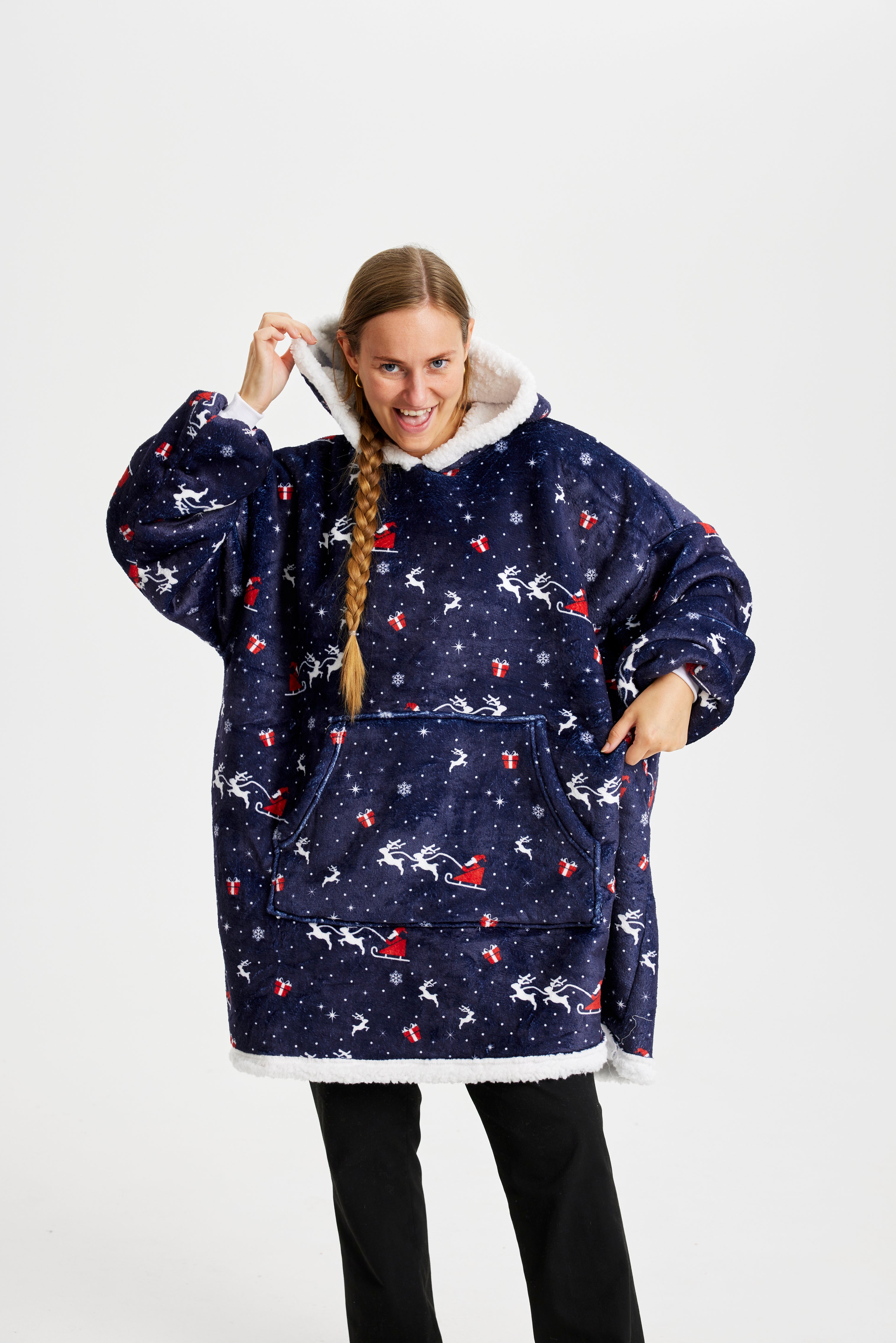 Une femme posant avec un sweat de Noël bleu foncé.