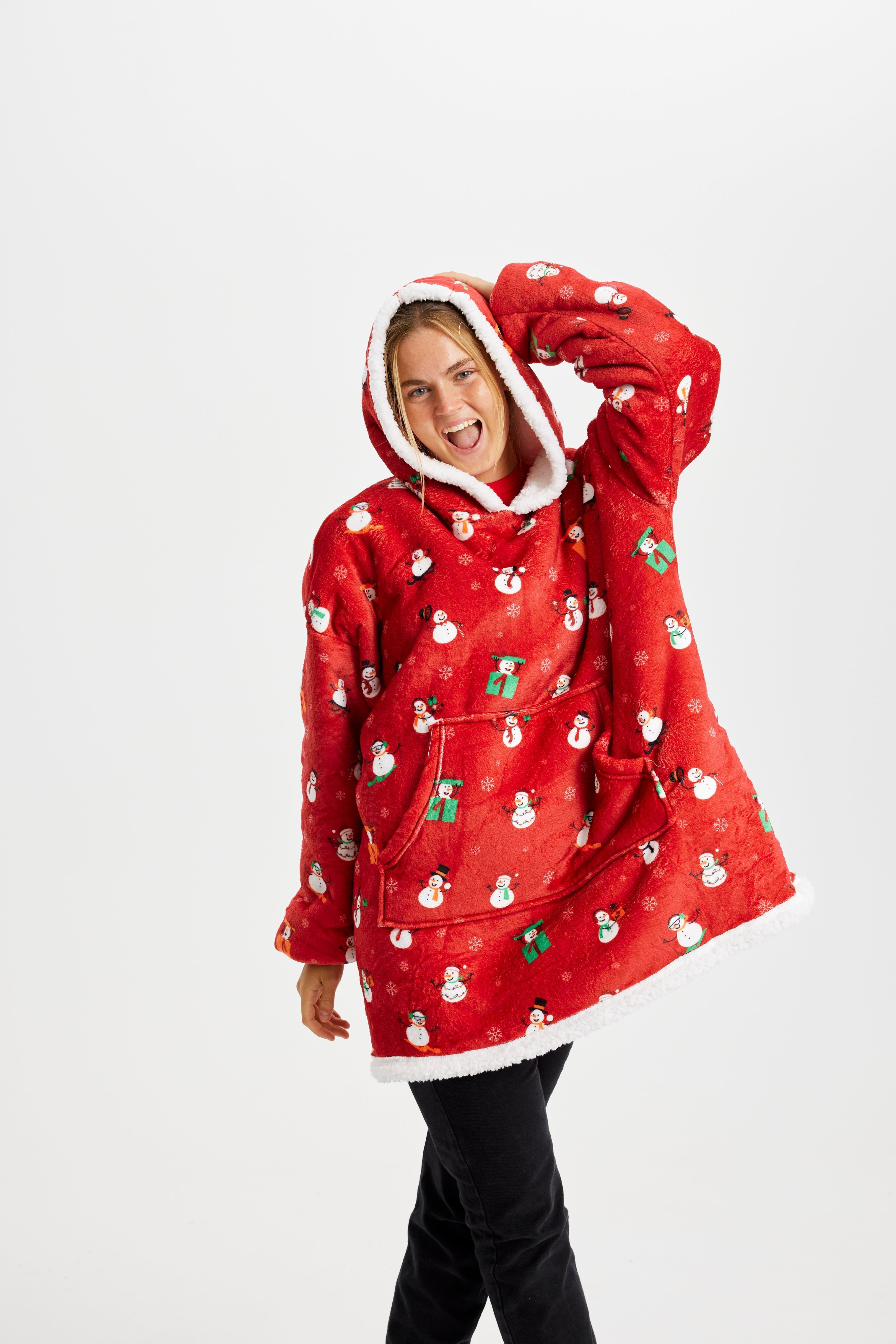 Une femme qui pose porte un sweat à capuche rouge avec un motif de Noël.