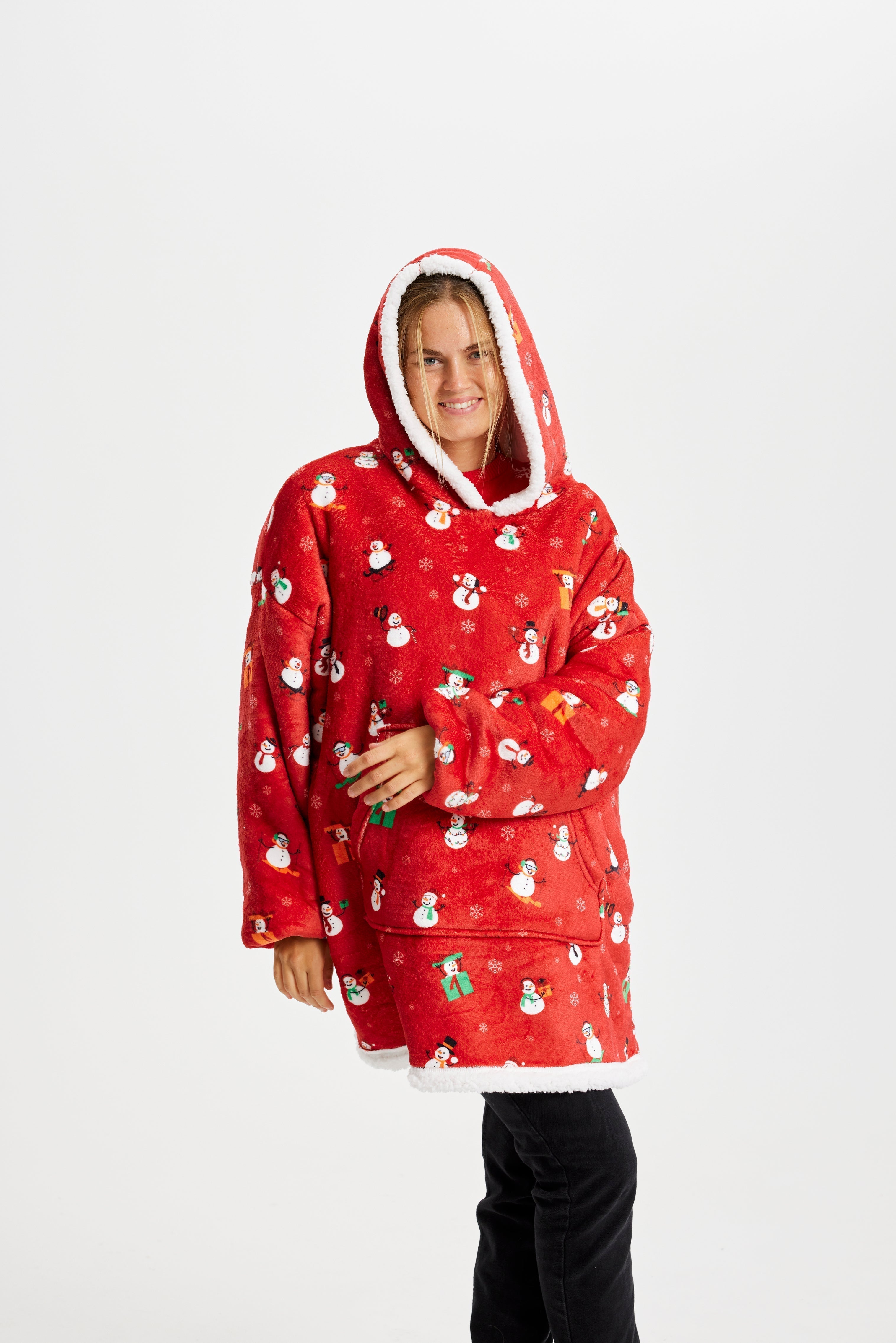 Une femme porte un sweat à capuche rouge avec un motif de Noël.