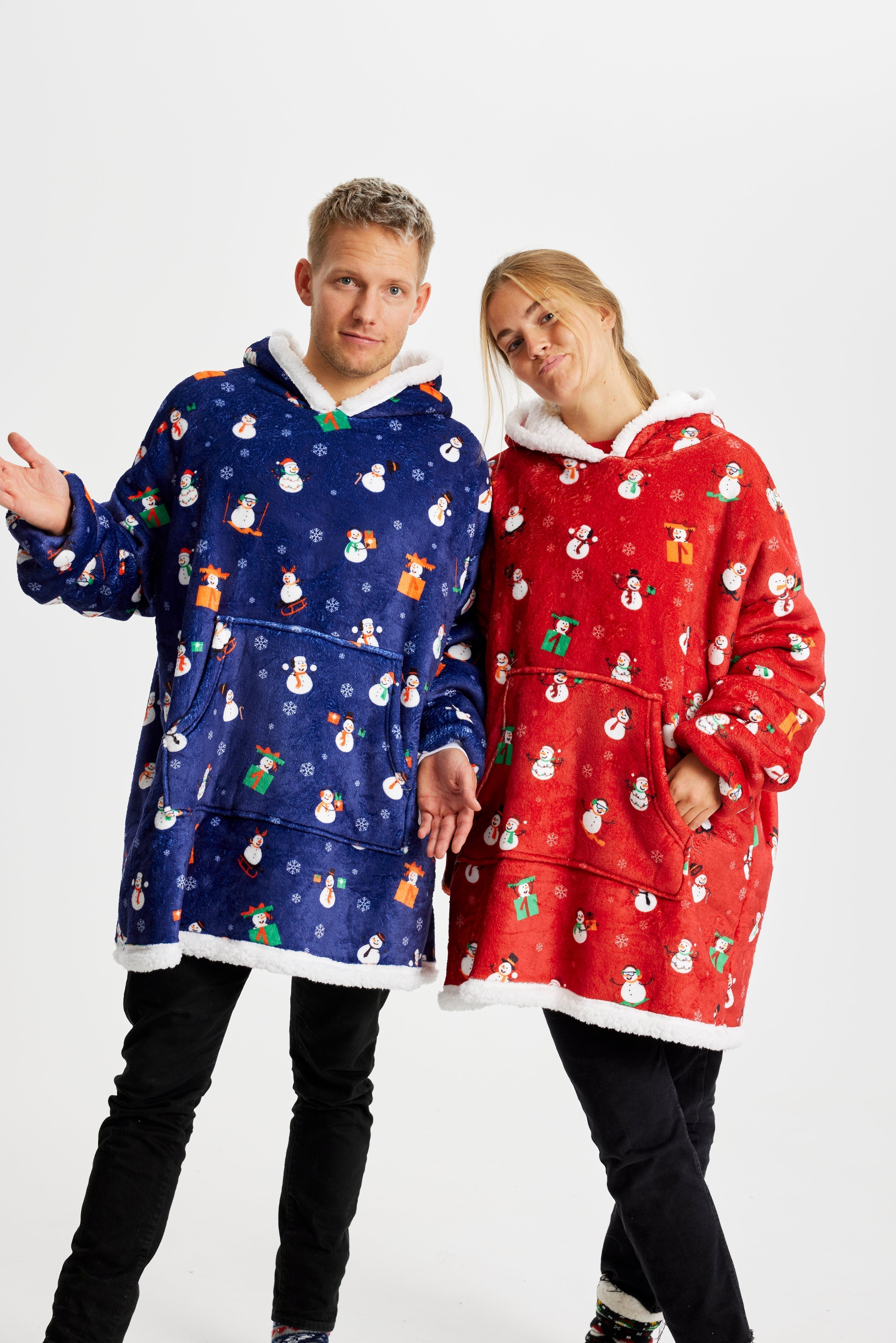 Un couple qui pose porte des sweats à capuche de Noël avec un motif de Noël.