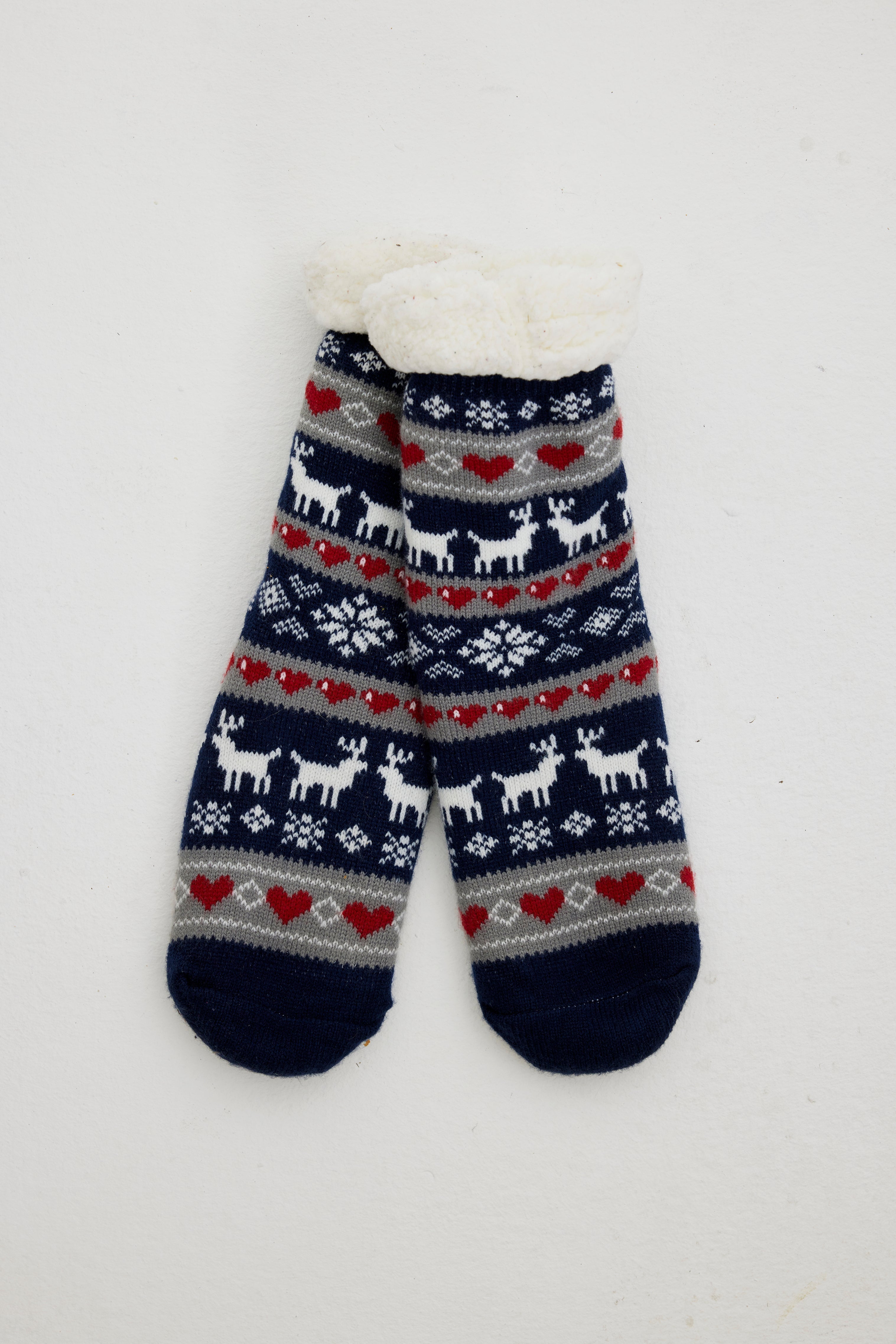 Une paire de chaussettes de Noël bleues ornées de rennes et de cœurs.