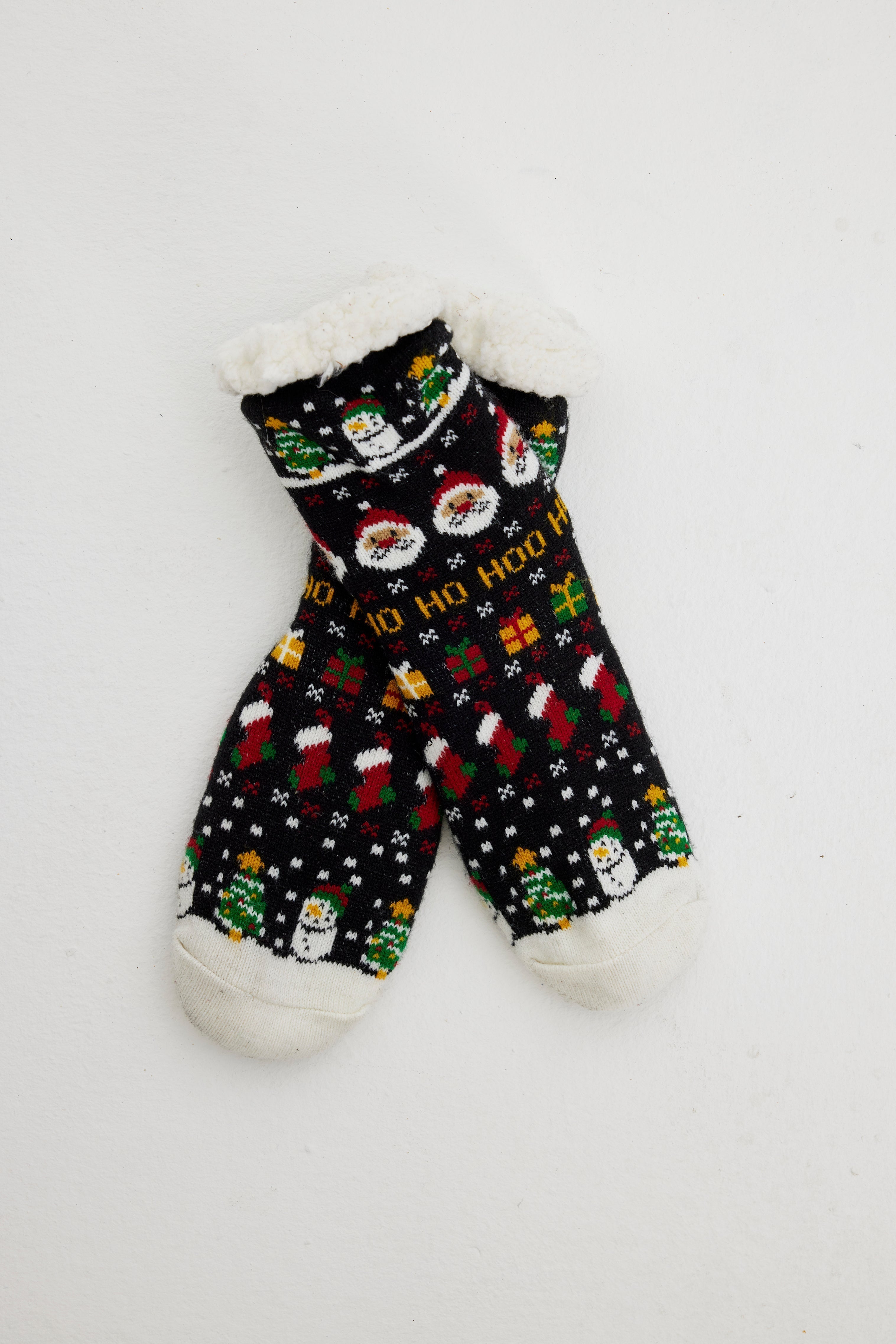 Une paire de chaussettes de Noël noires ornées d'un motif de Noël.