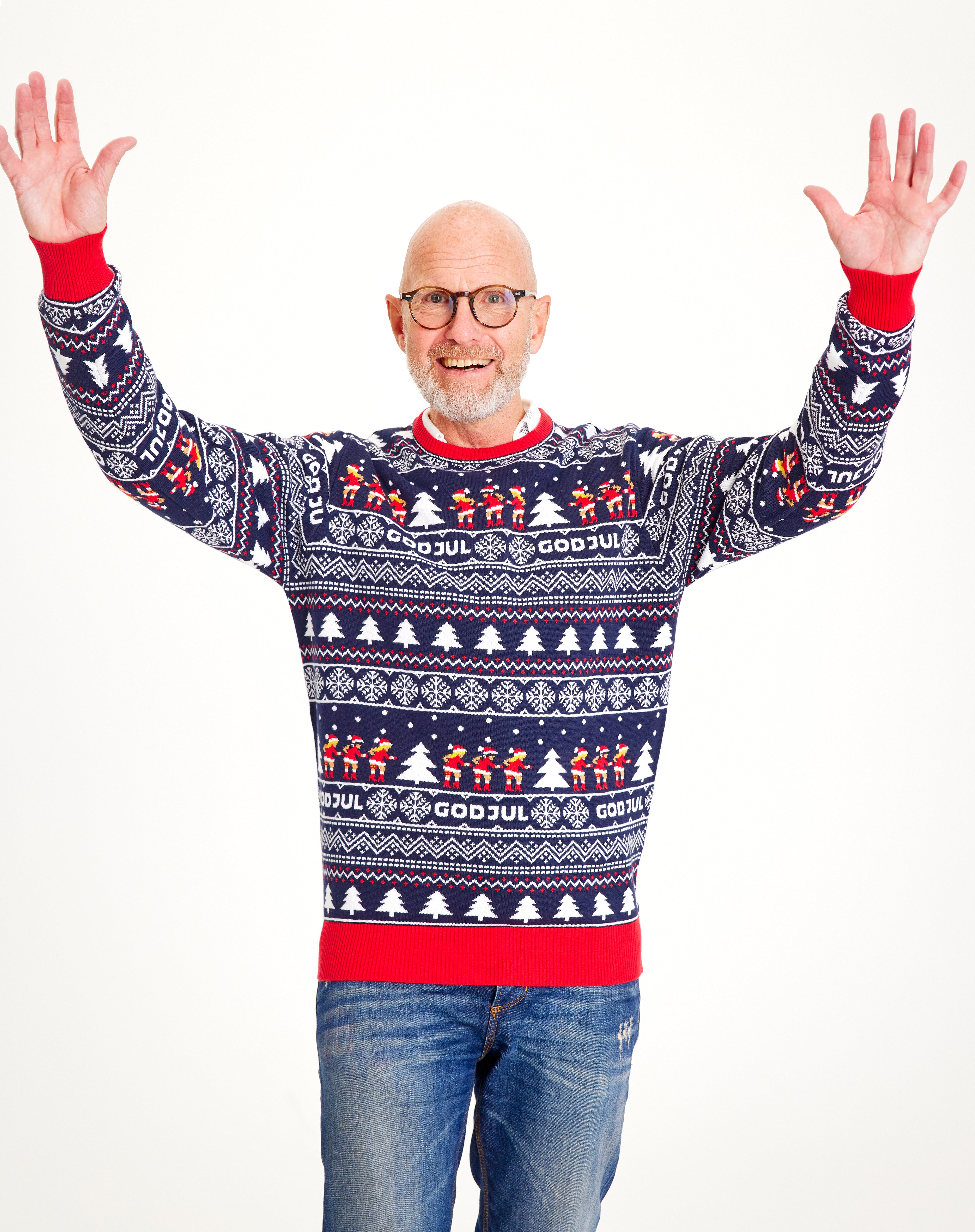 Un homme posant avec un pull bleu à motifs de Noël.