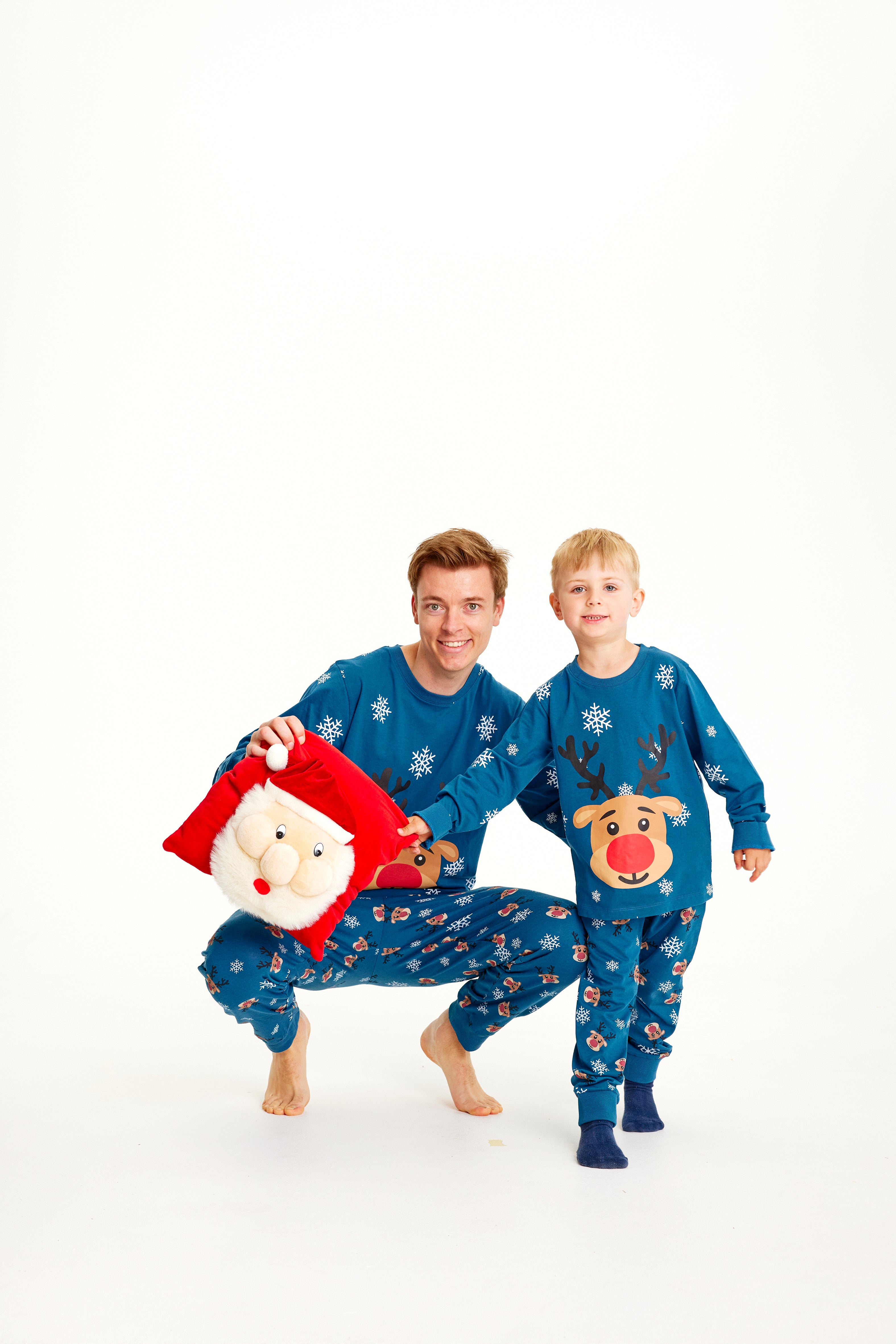 Un enfant et un homme portant un pyjama de Noël bleu avec Rudolph.