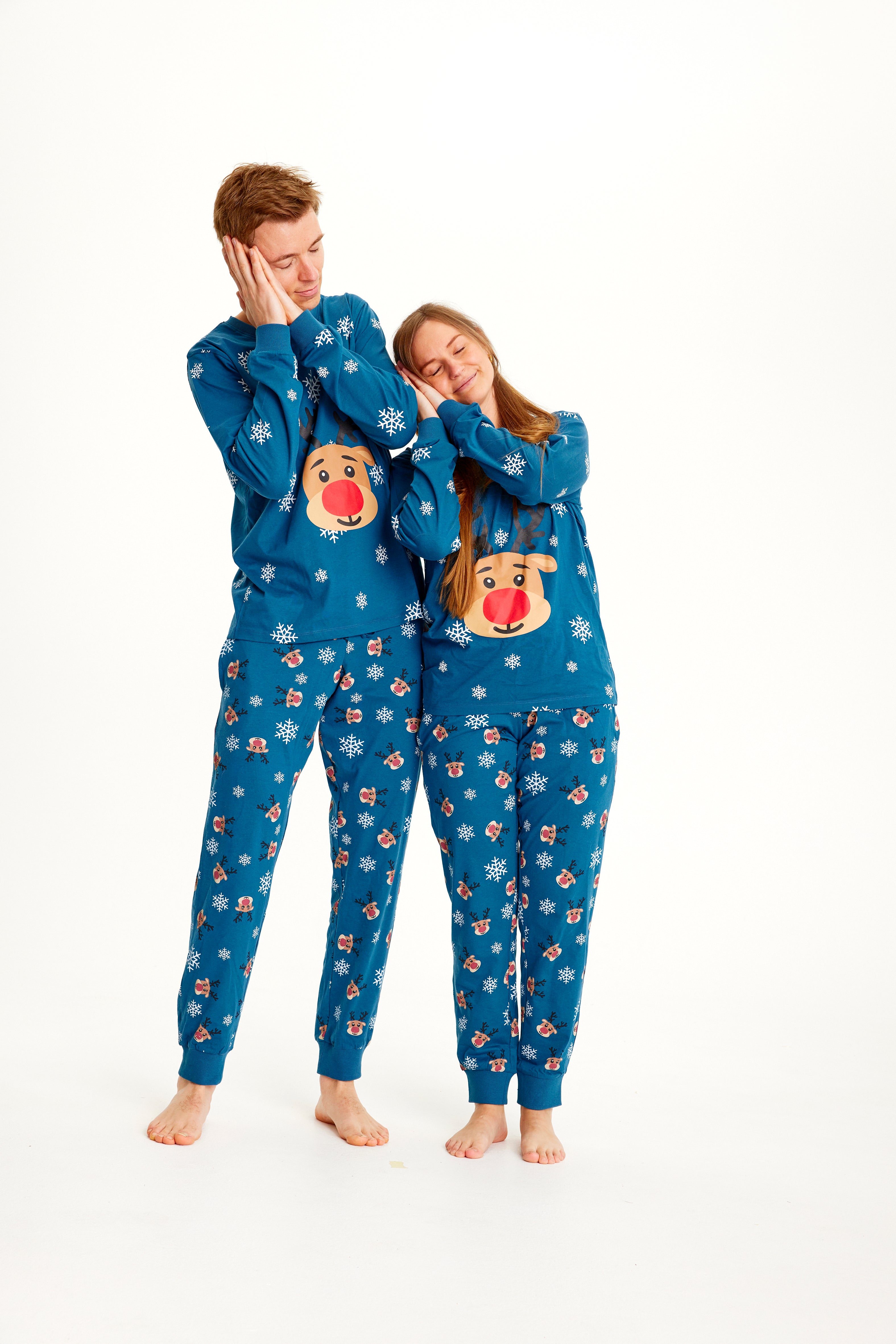 Un couple endormi portant un pyjama de Noël bleu avec Rudolph.