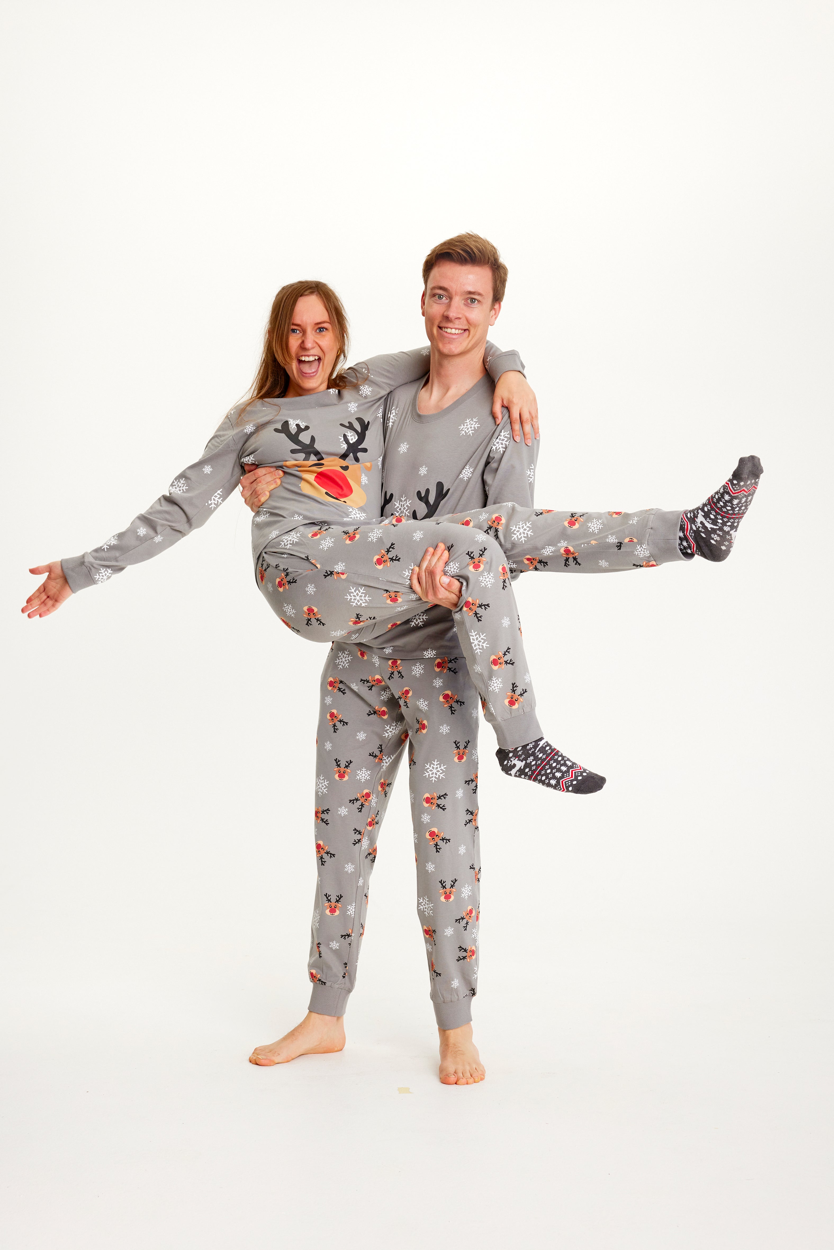 Un couple posant en pyjama de Noël gris avec Rudolph.