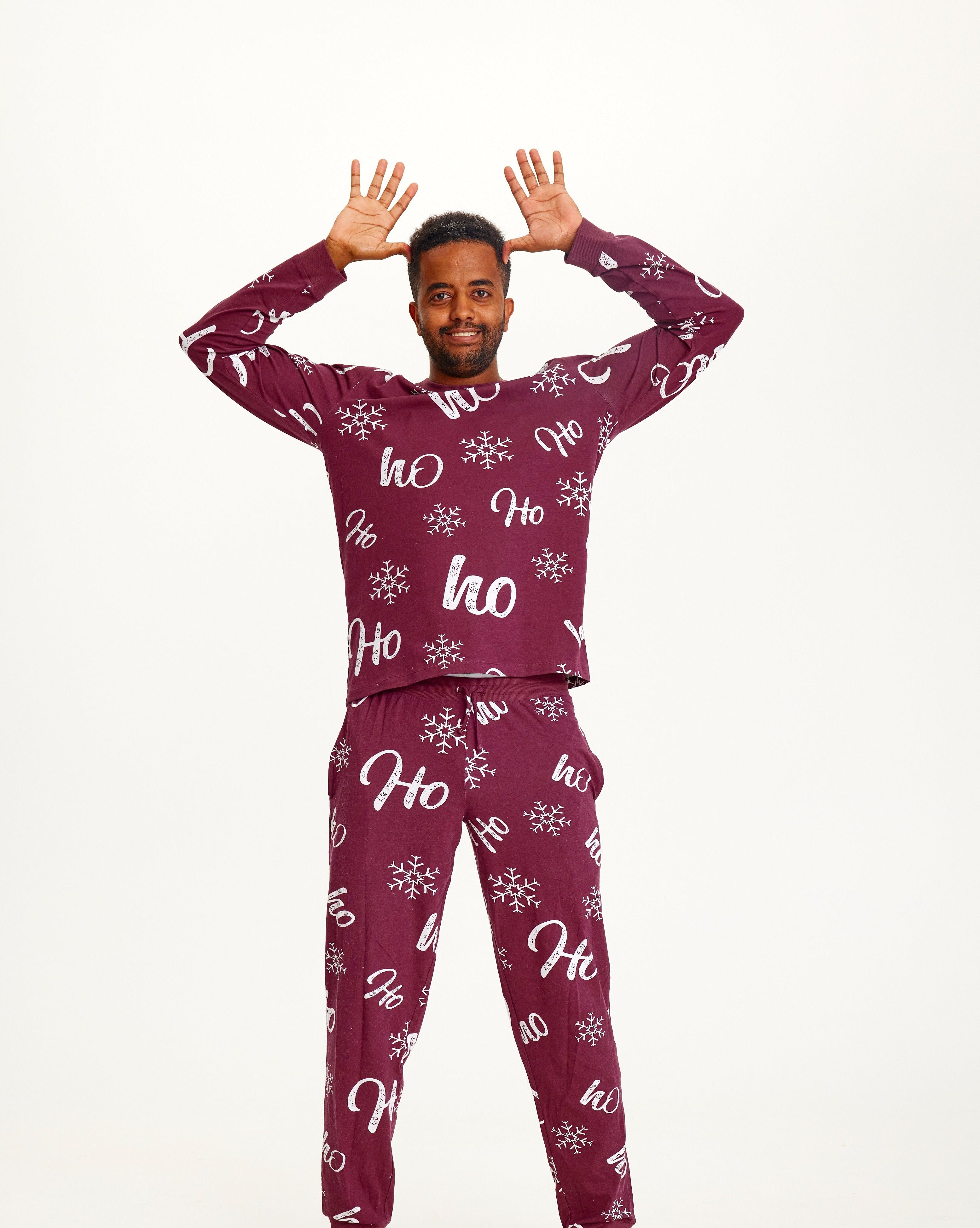 Un homme portant un pyjama de Noël rouge foncé.