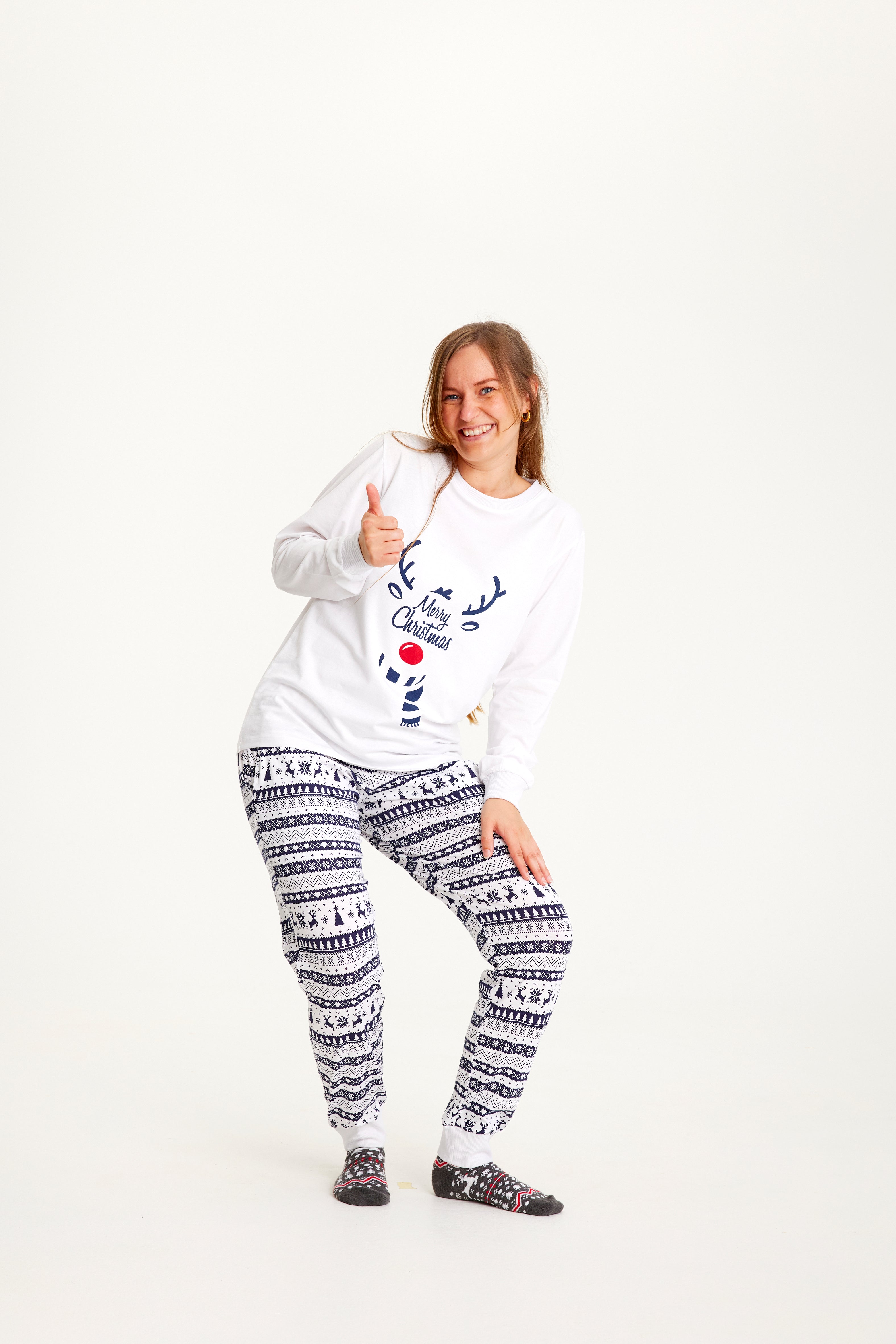 Une femme posant avec un pyjama de Noël blanc.