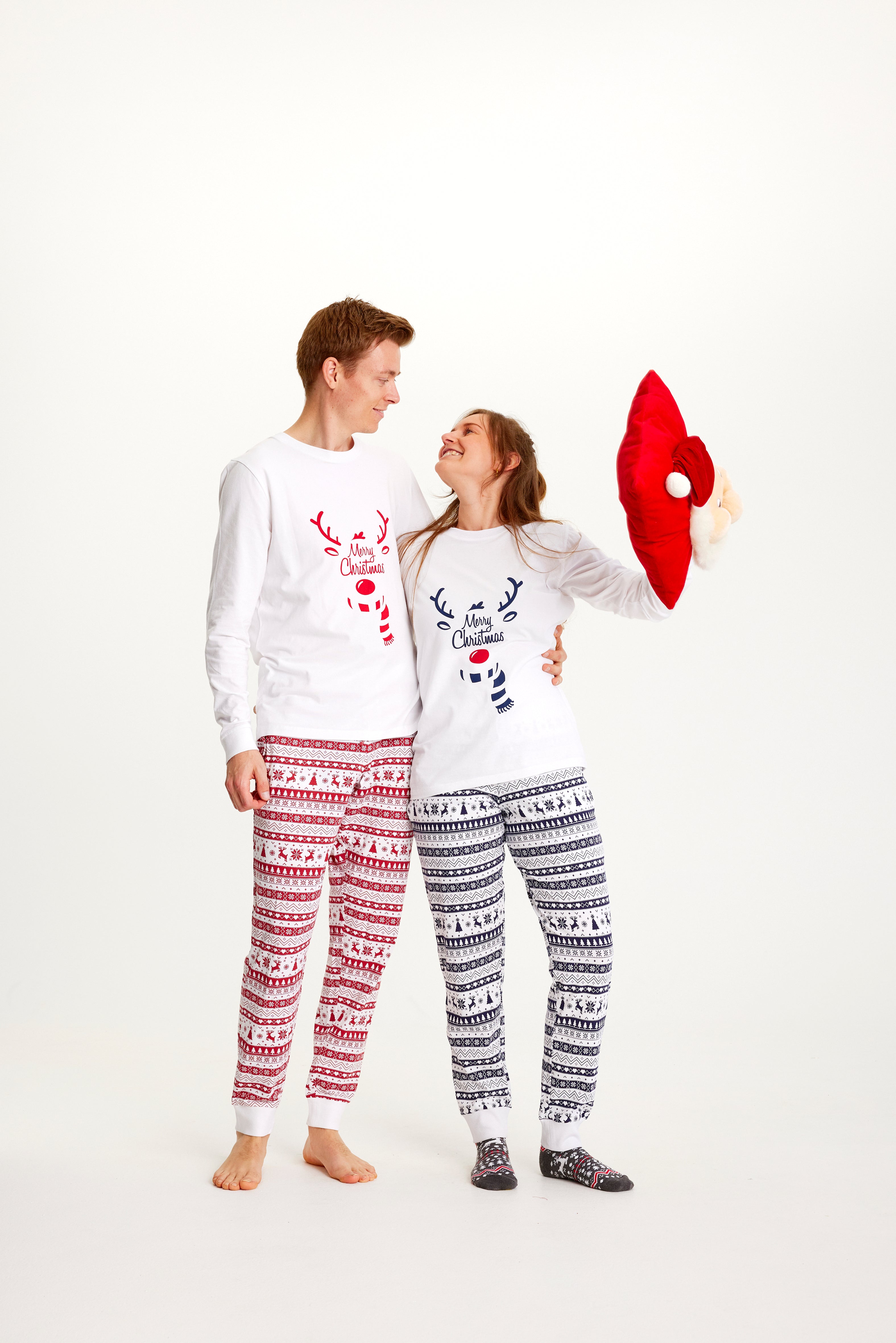Un couple se regardant l'un l'autre en pyjama de Noël blanc.