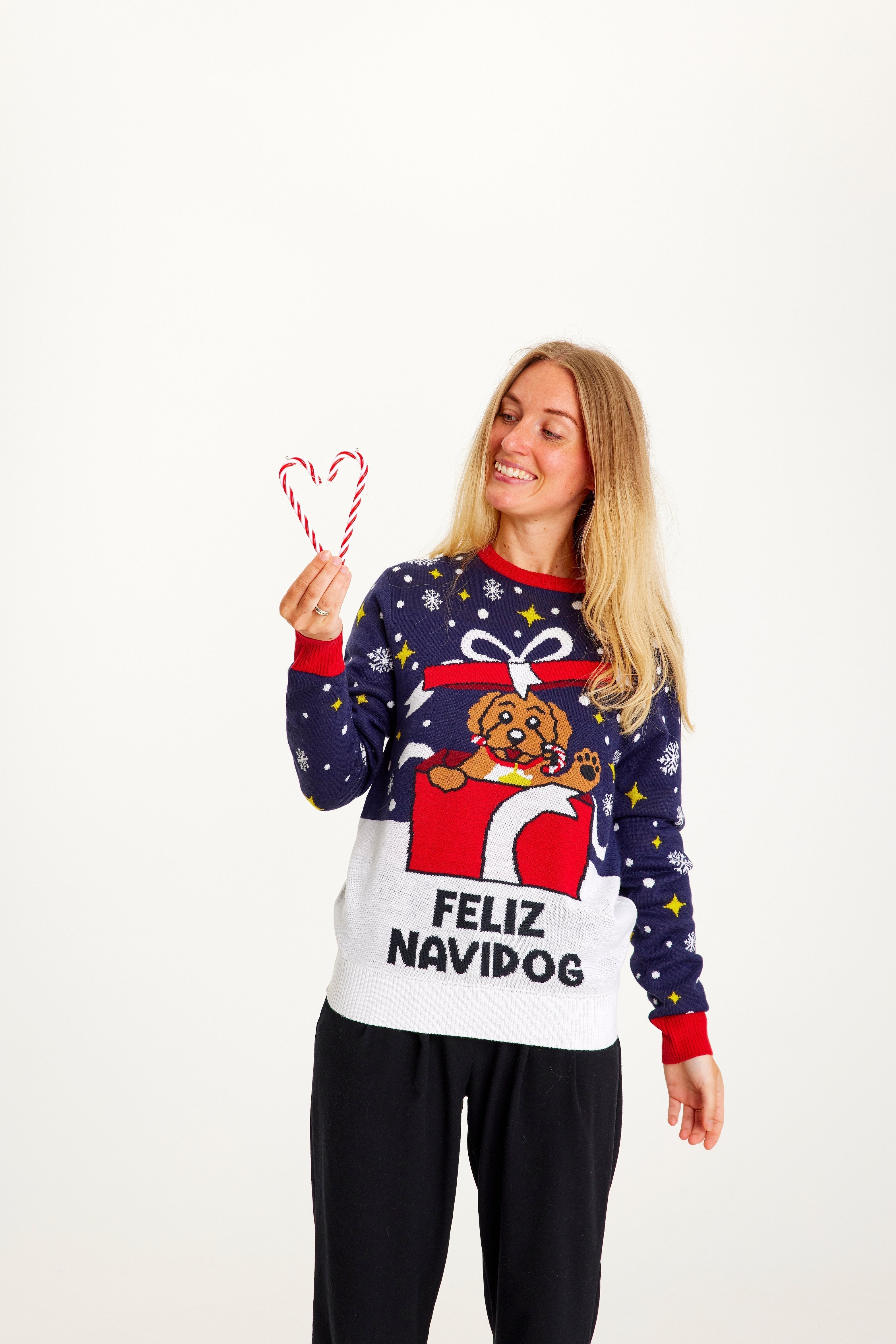 Une femme porte un pull de Noël avec un chien dessus.