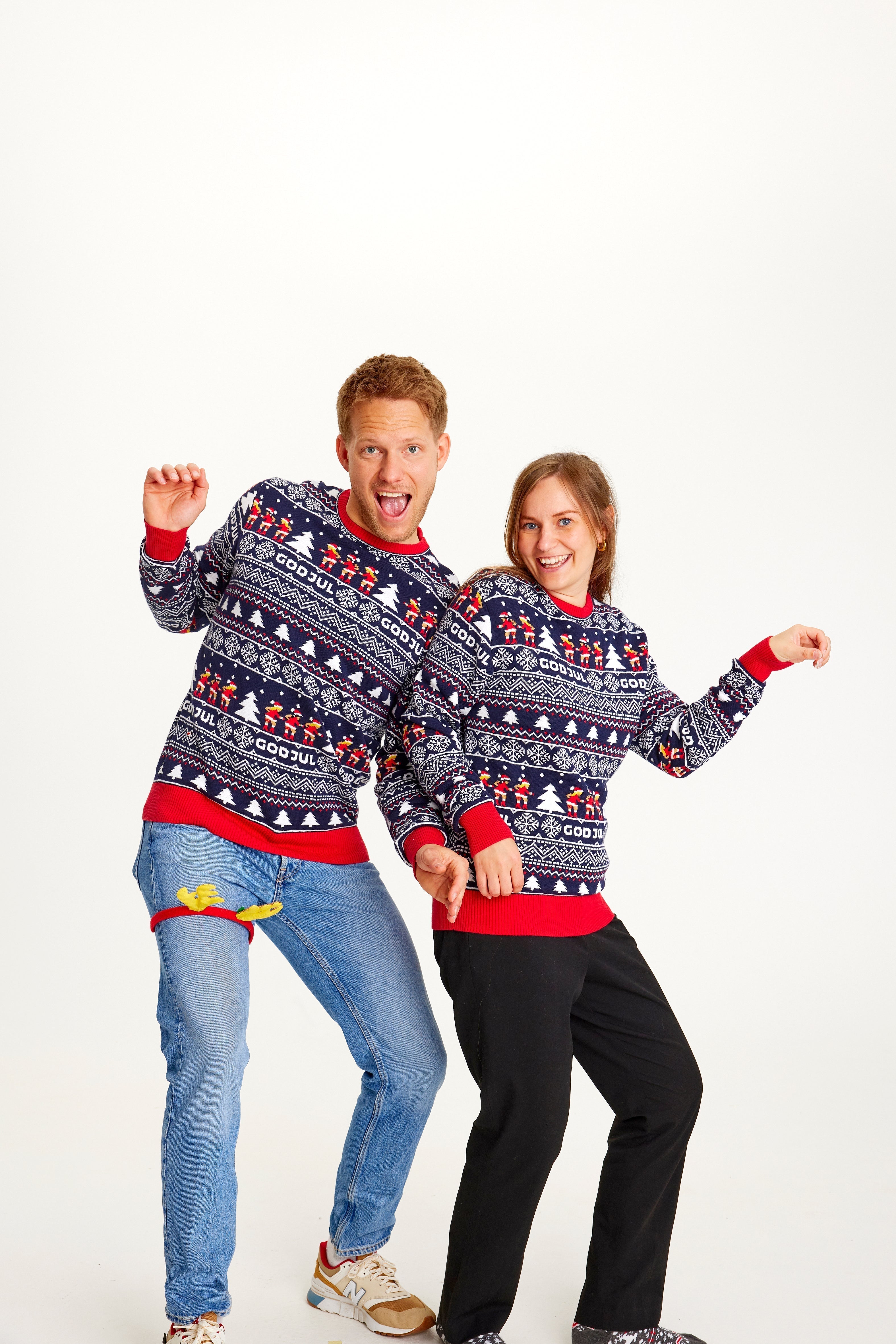 Un couple portant un pull de Noël à motifs bleus.