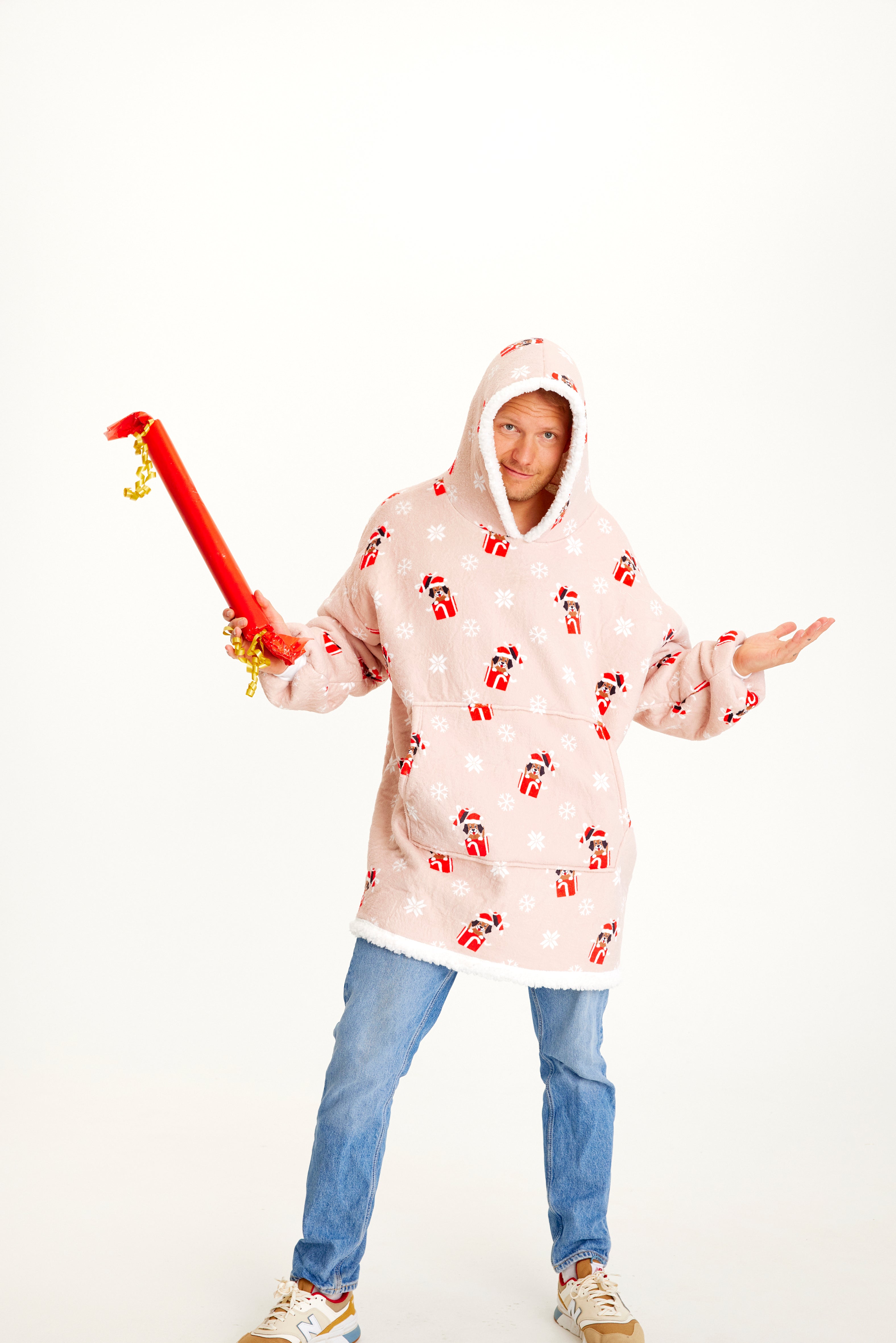 Un homme portant un sweat à capuche de Noël rose avec des chiens.