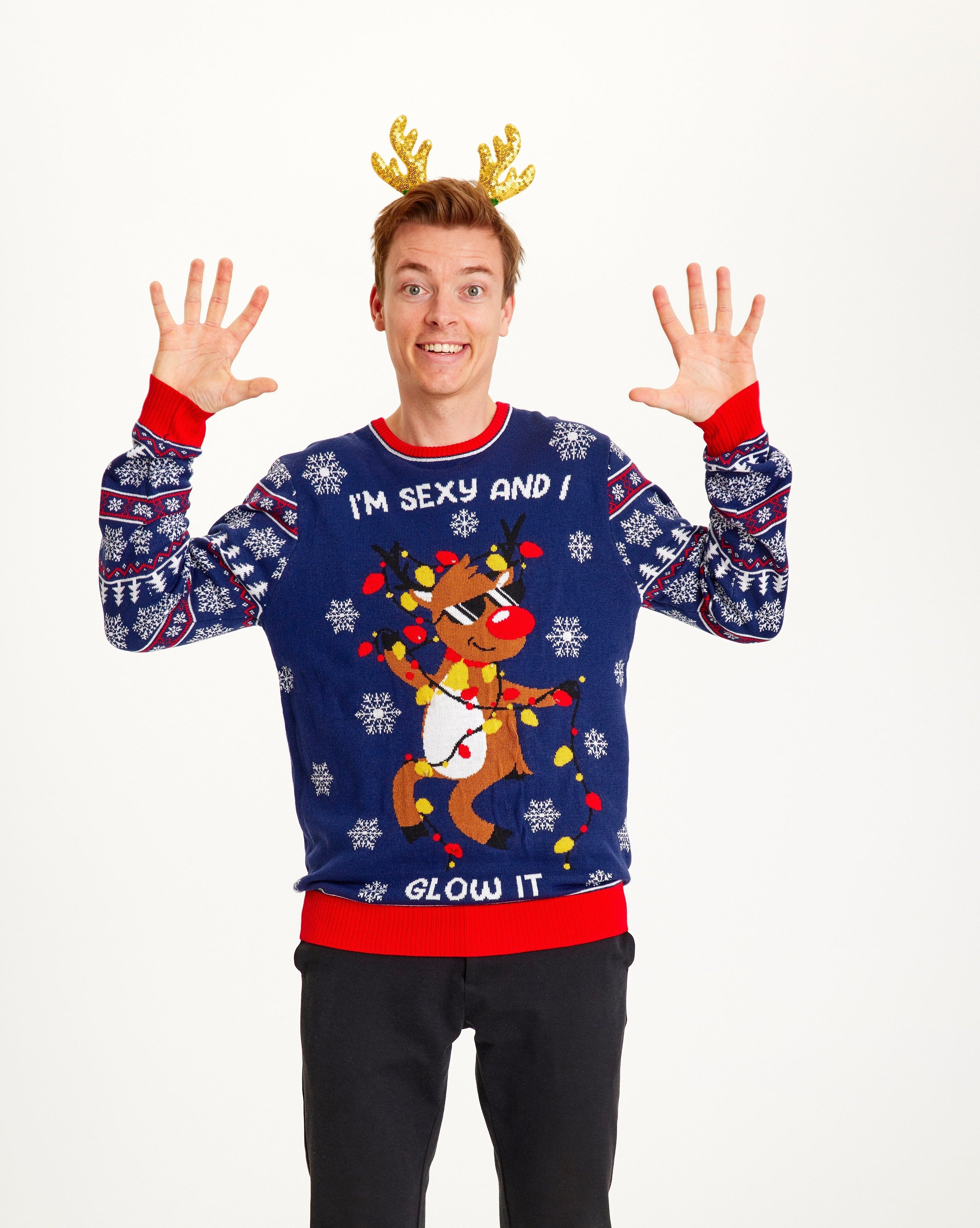 Un homme portant un pull bleu de Noël avec un renne dansant et des lumières.